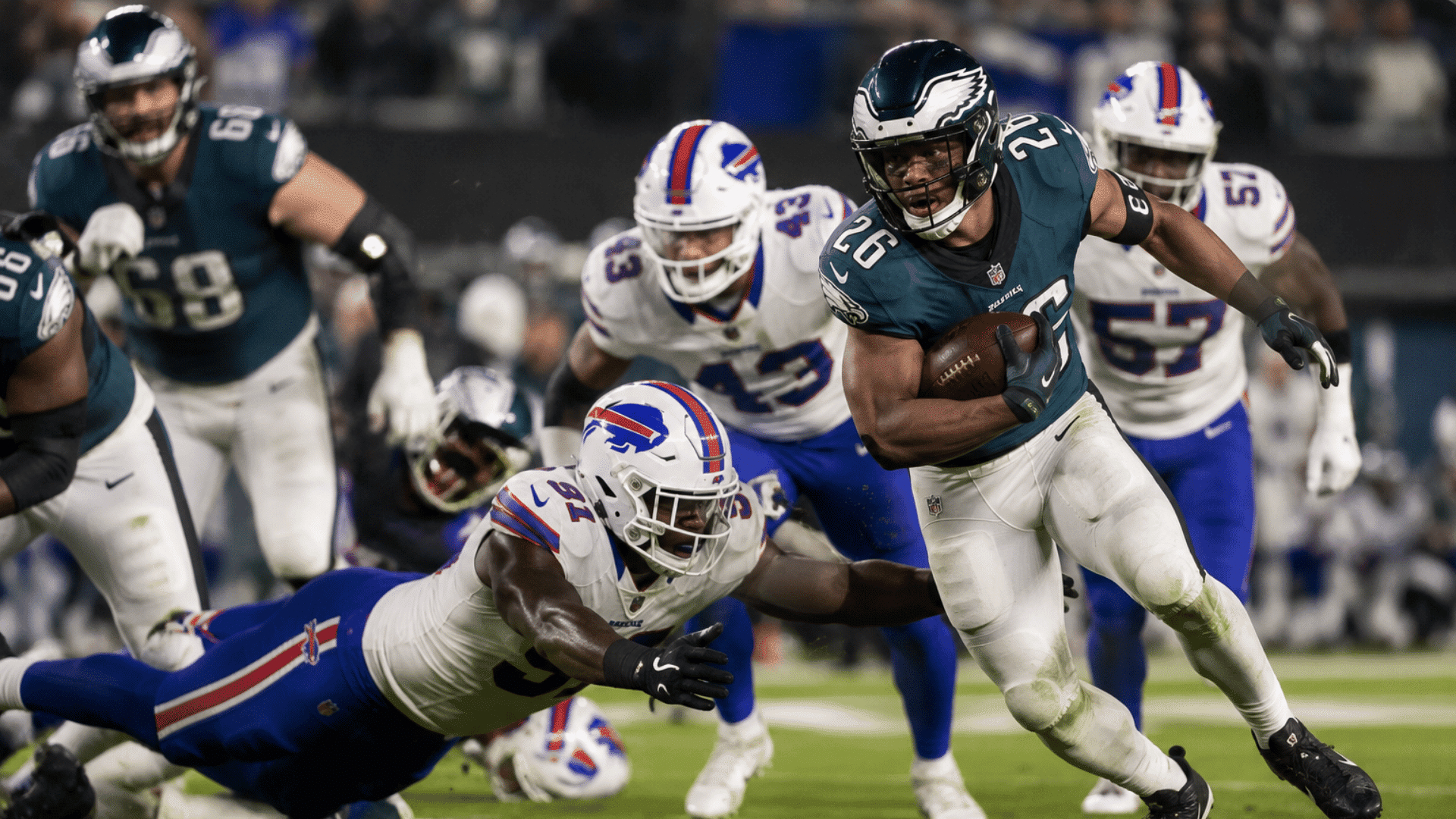 american football player breaking through a tackle during a night game under bright stadium lights