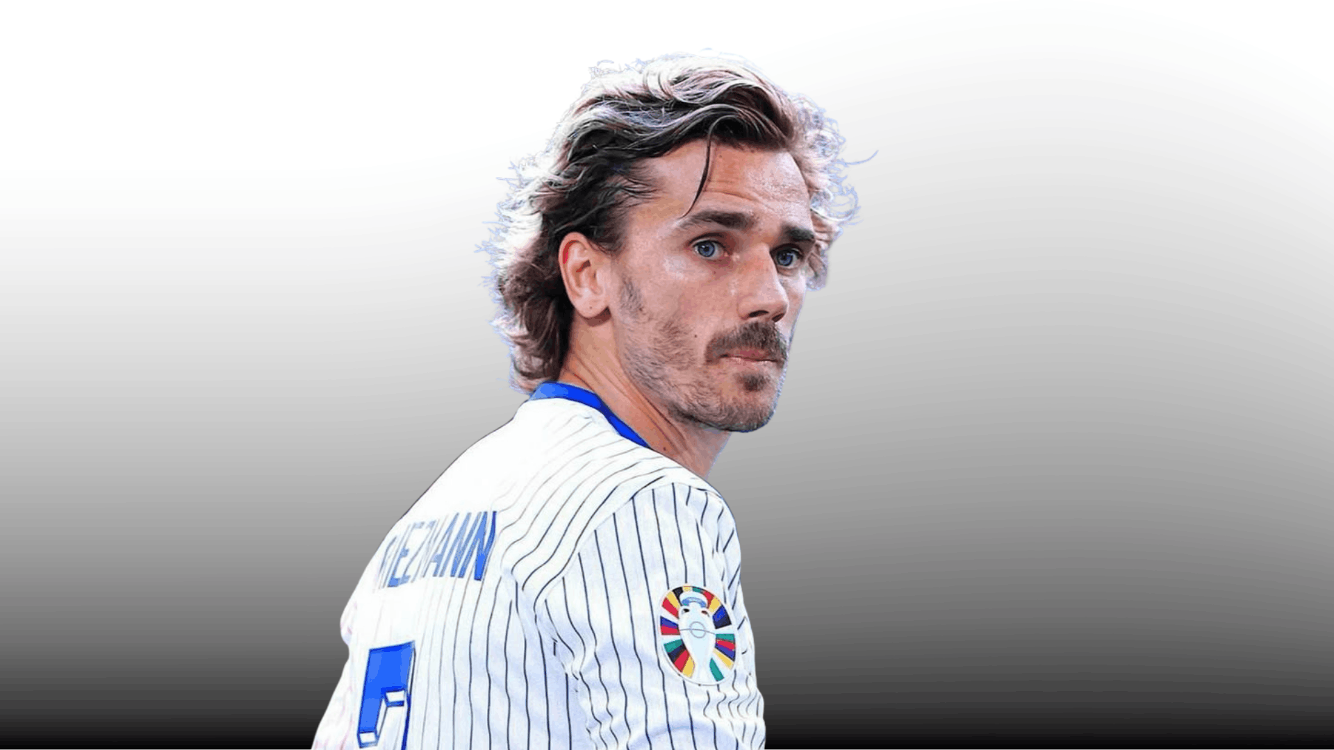 antoine griezmann with wavy medium length hairstyle wearing white striped jersey on gray gradient background