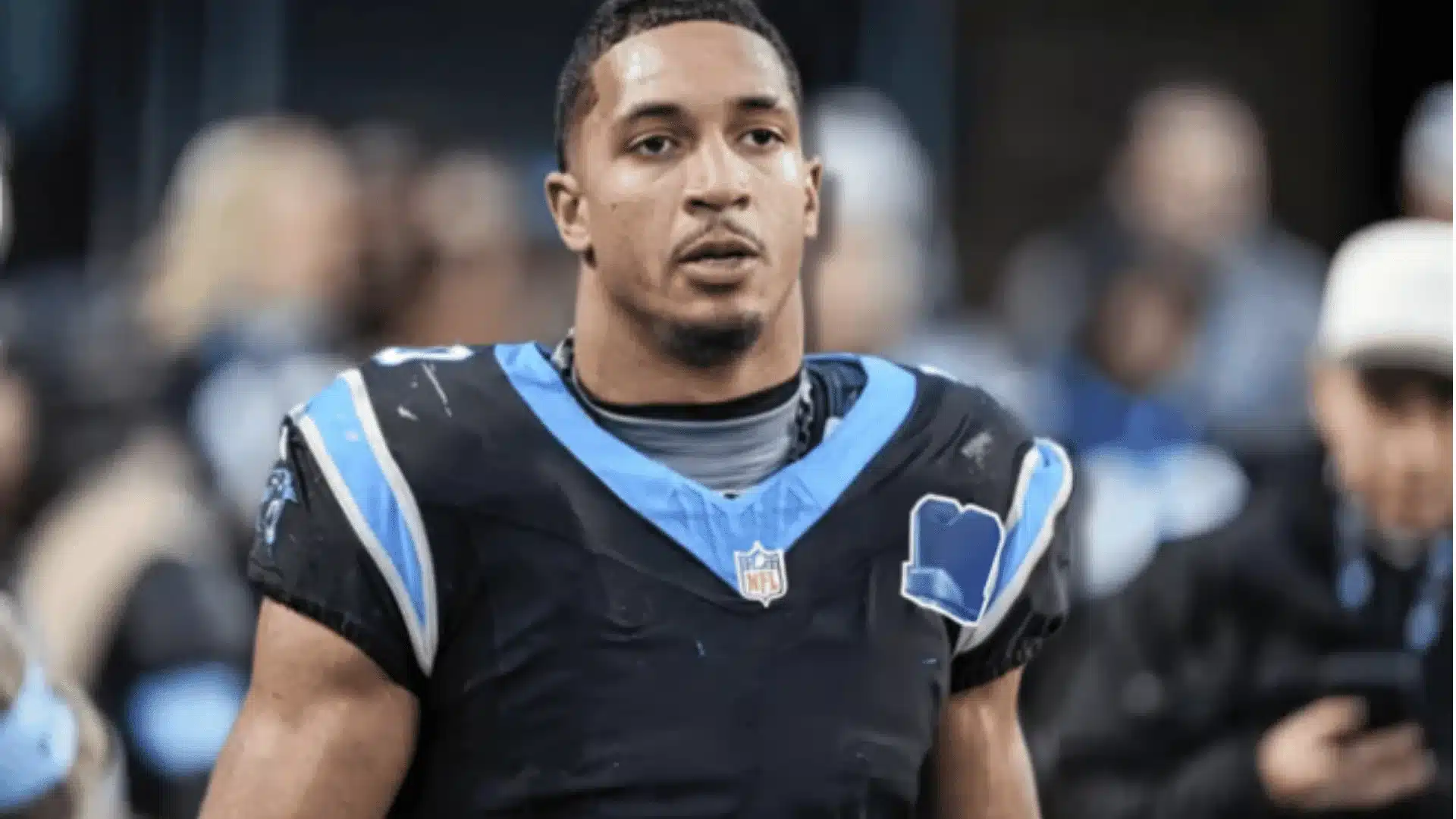 chuba hubbard wearing a carolina panthers jersey standing on the field during a game