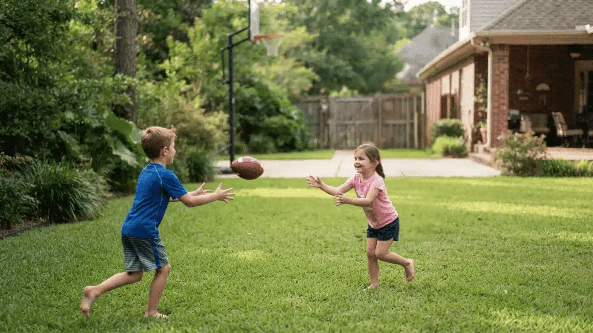 young children throwing football while older teen practices advanced throwing stance