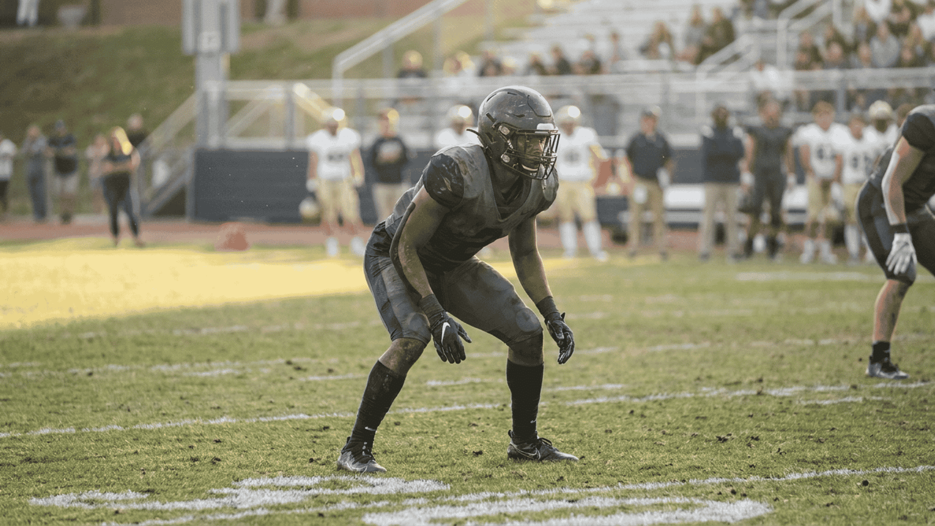 defensive back in a ready stance on the field representing the db position (1)