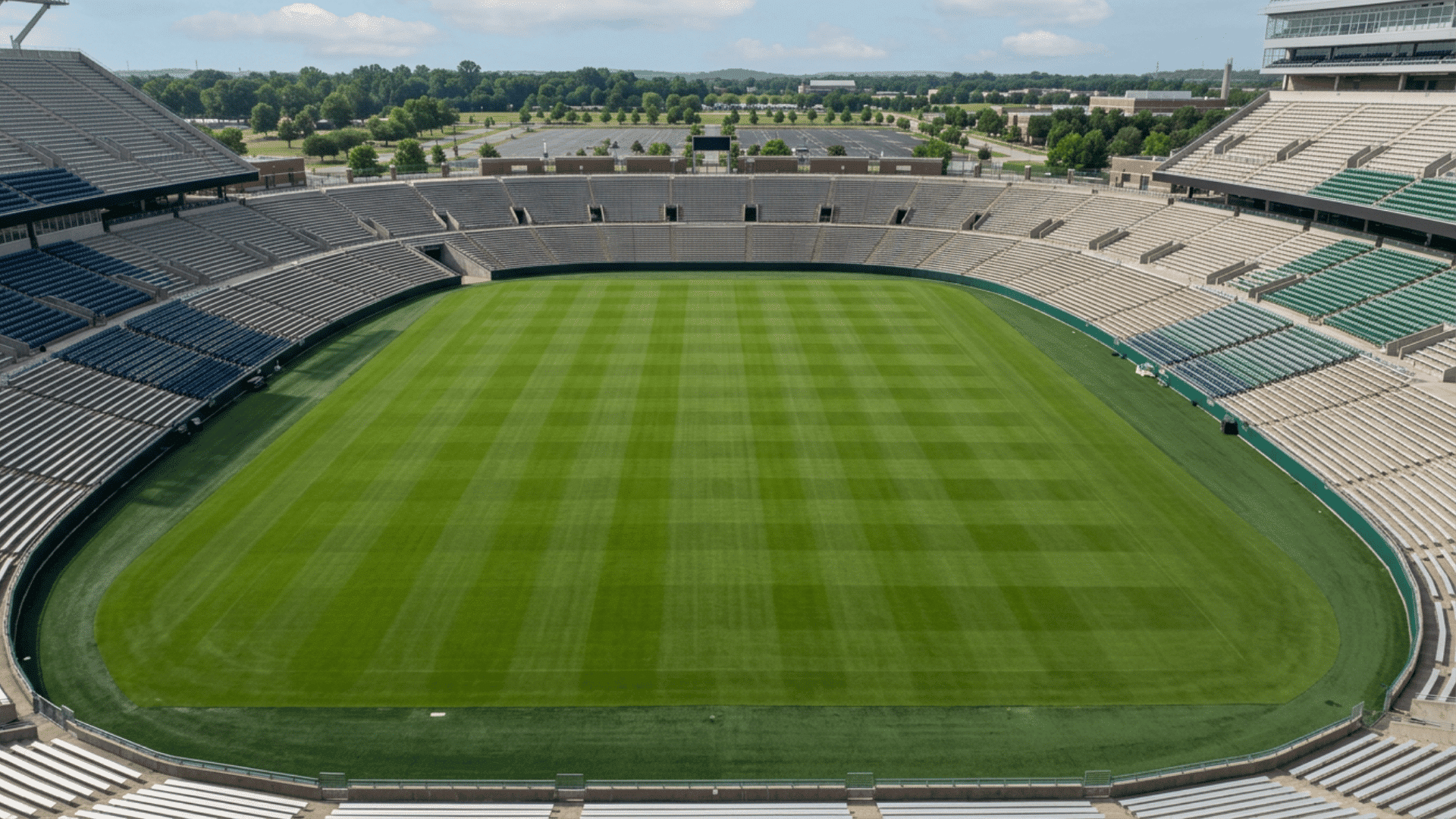 empty football stadium with marked field goal posts and numbered yard lines viewed from stands