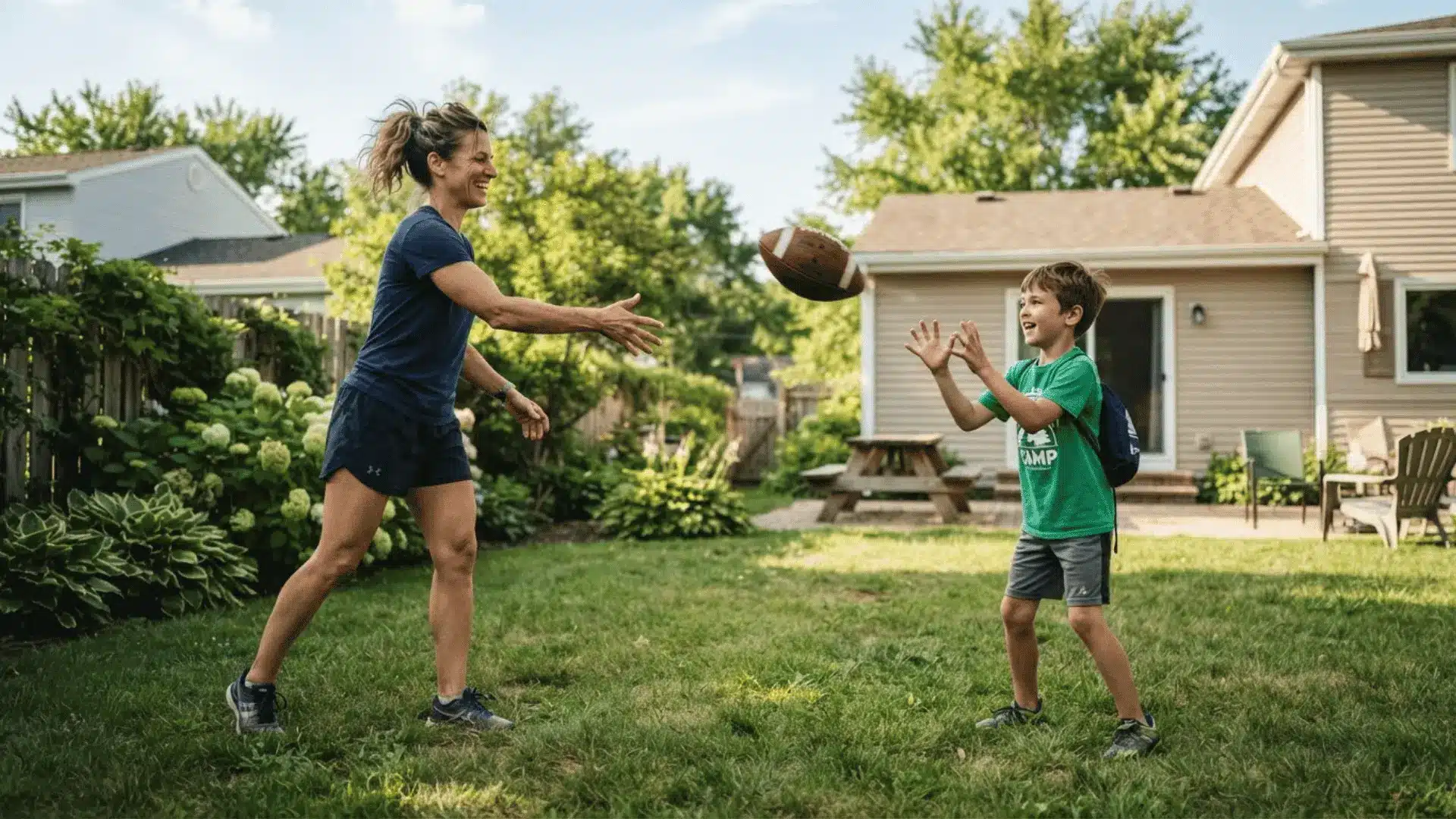 parent tossing football to child in backyard to practice basic catching skills