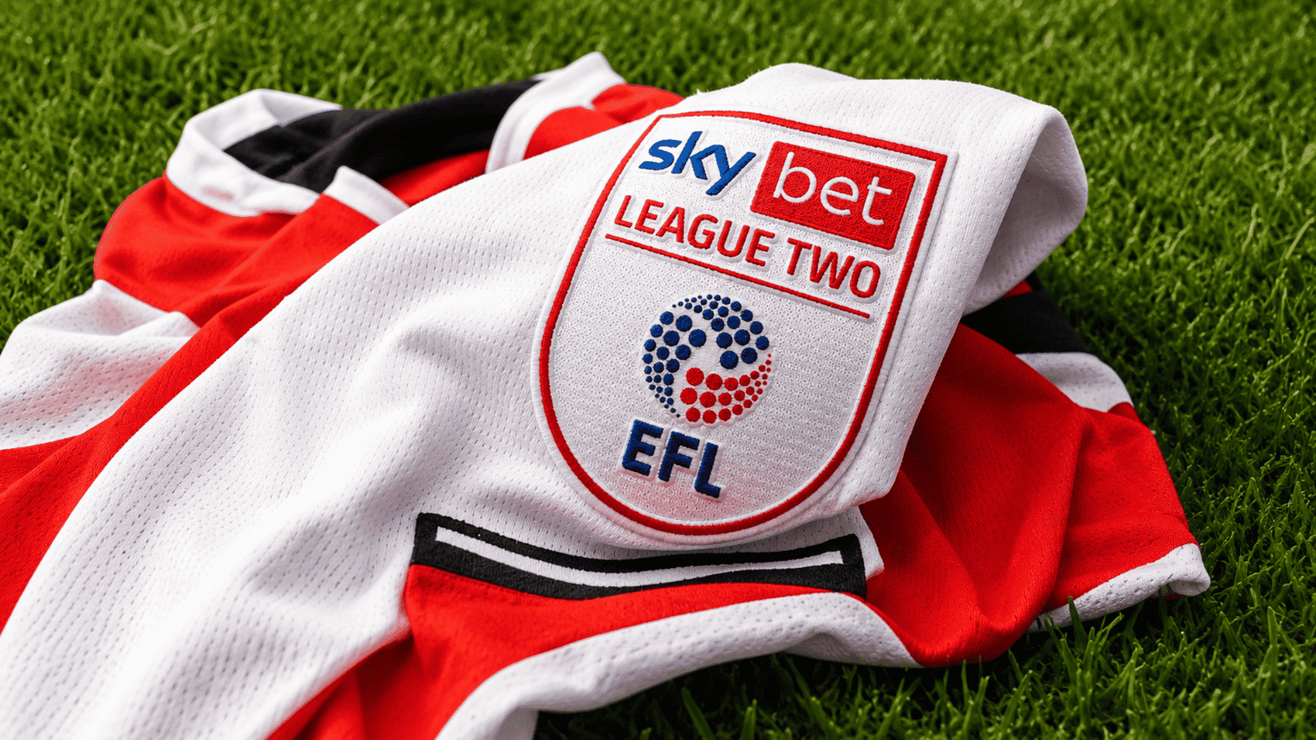 league two football shirt resting on green grass with embroidered efl competition badge