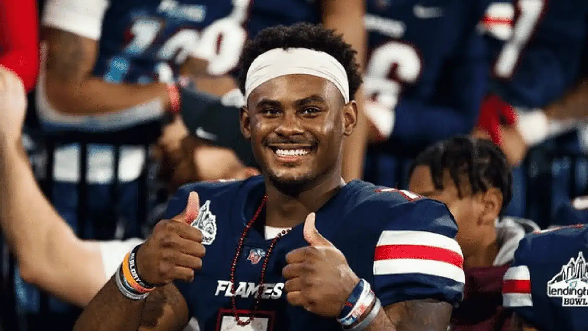 malik willis giving a thumbs up in a liberty university flames jersey after a game