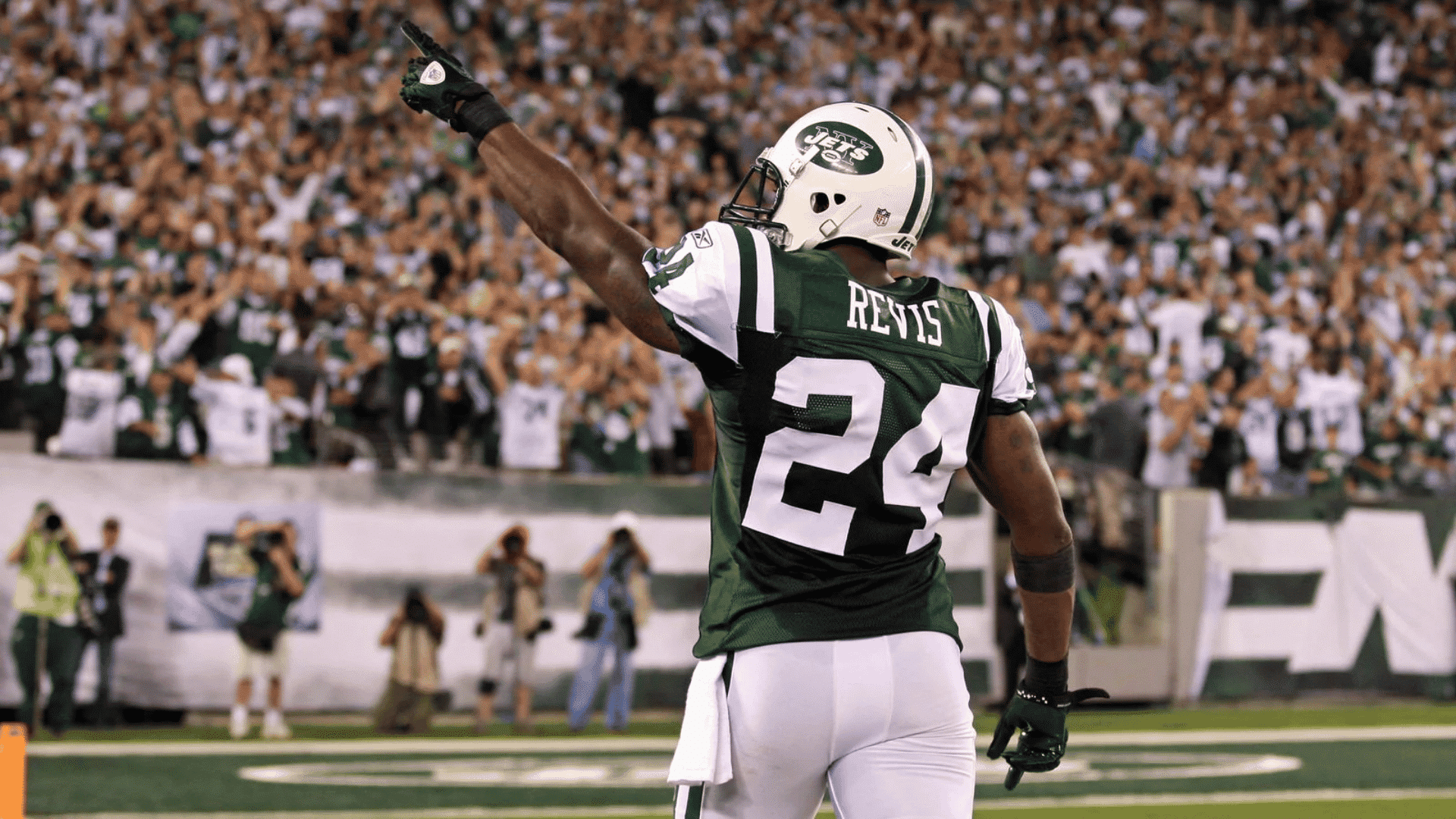 new york jets defensive player darrelle revis wearing green jersey number twenty four pointing to the crowd