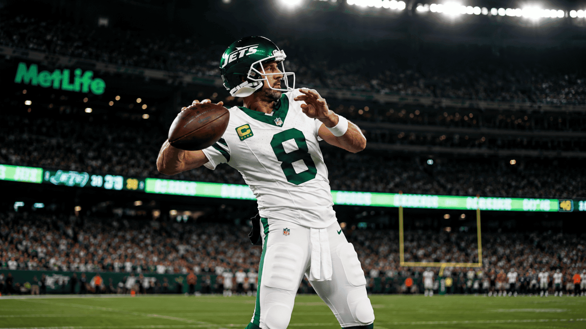 new york jets quarterback prepares to throw the football under bright stadium lights during a night game