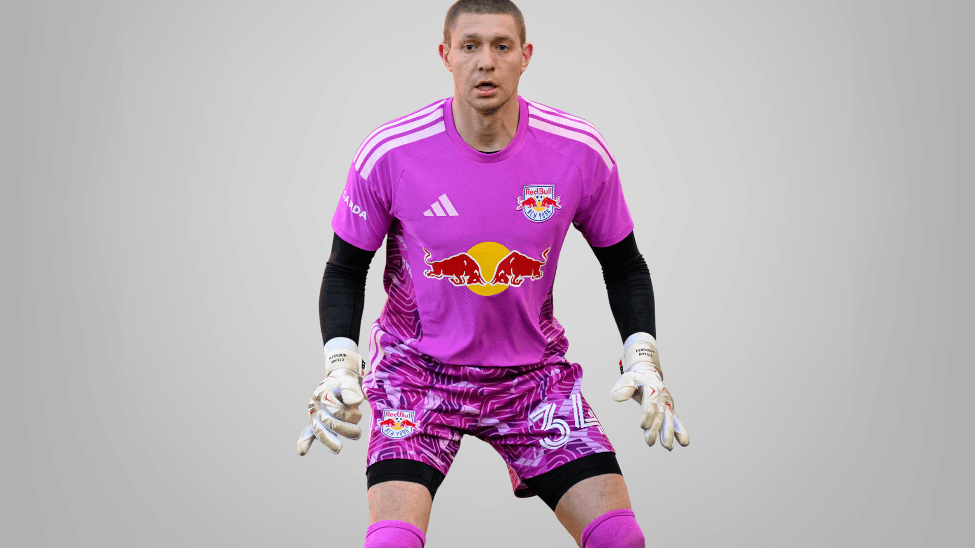 new york red bulls goalkeeper in bright pink kit standing ready on a clean grey background