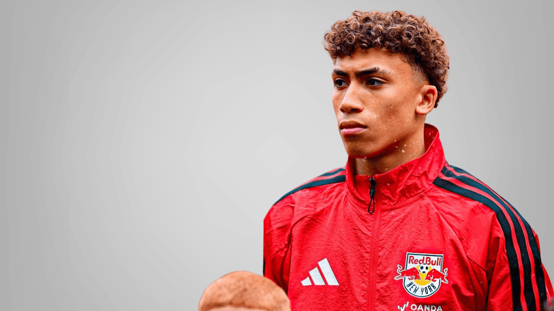 new york red bulls player in red jacket holding a ball on a clean grey background for match analysis