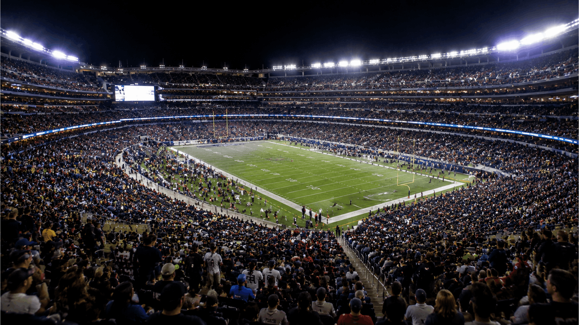 nfl stadium wide view during halftime with bright lights crowd in stands and empty field ready for second half action