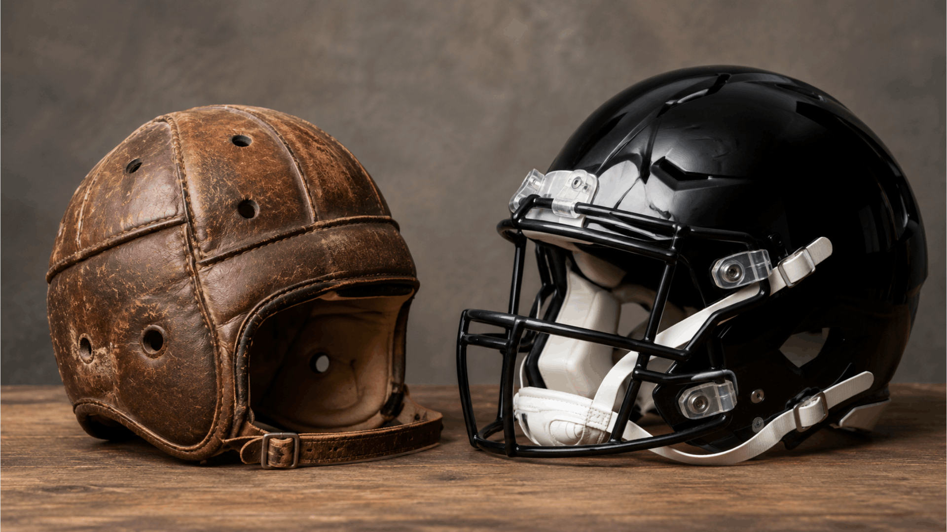 old leather football helmet beside a modern black helmet on a wooden table showing helmet evolution