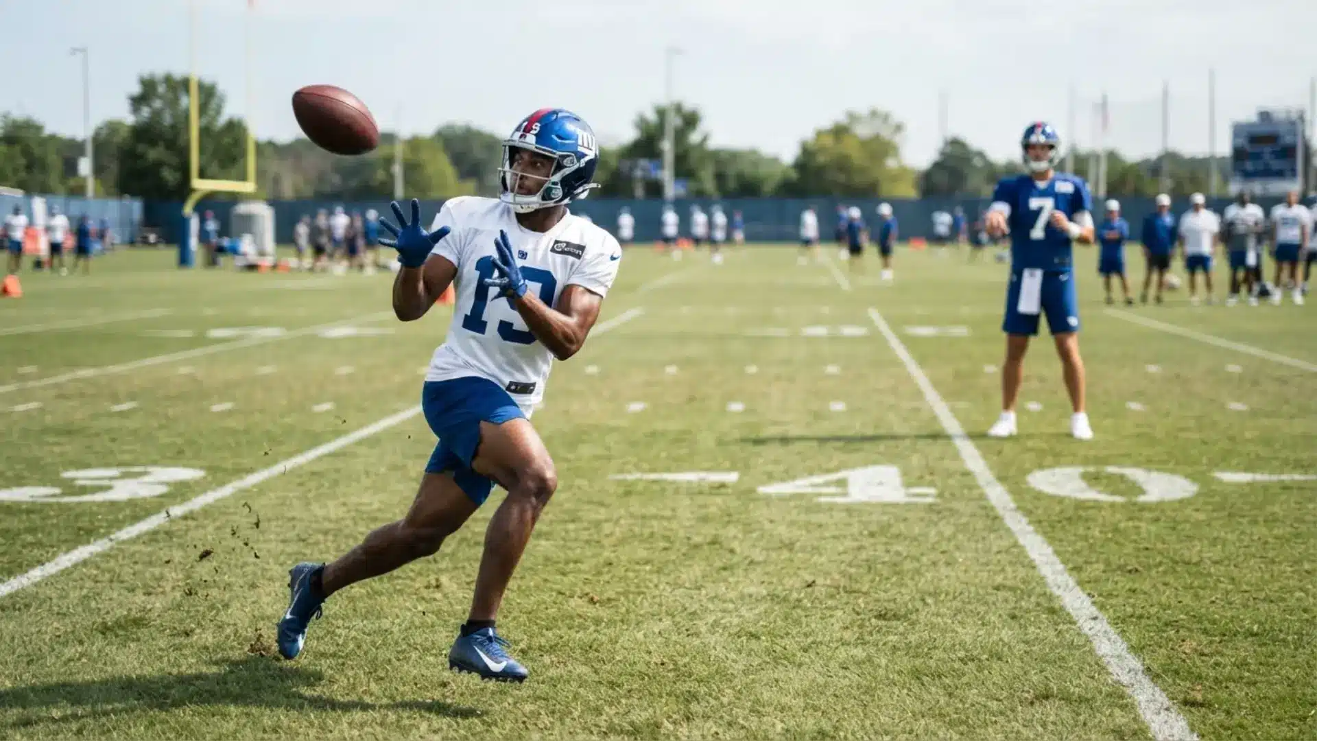 receiver tracks a deep football over his shoulder while running a go route drill at full speed