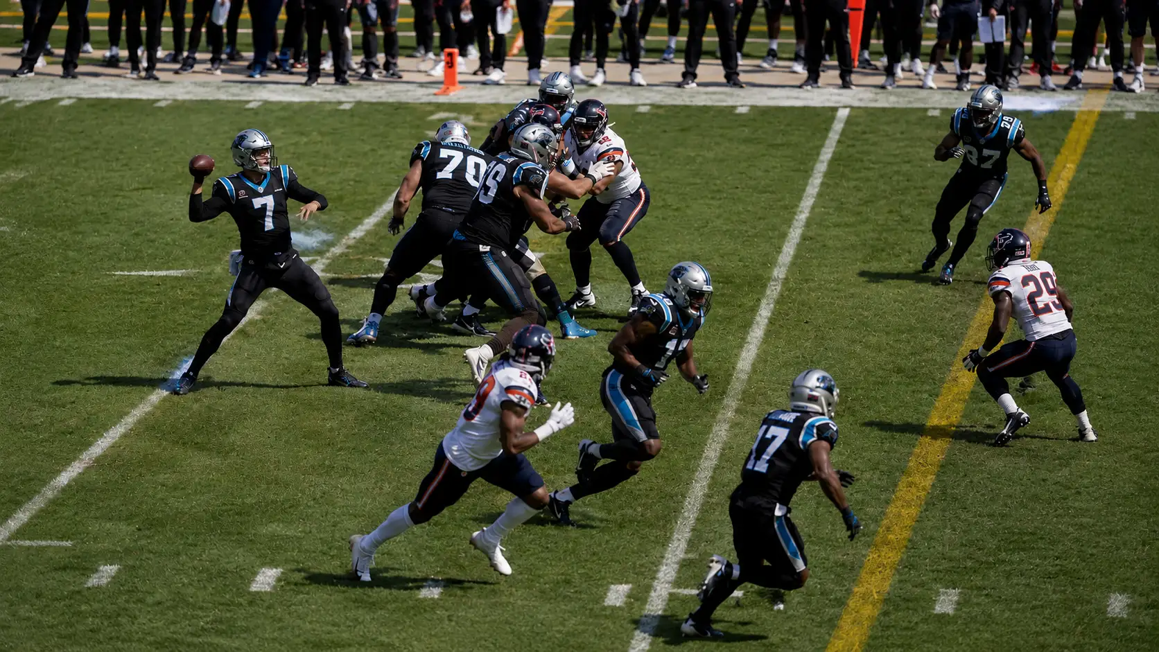quarterback prepares a quick throw near the first down marker as defenders close on crossing routes