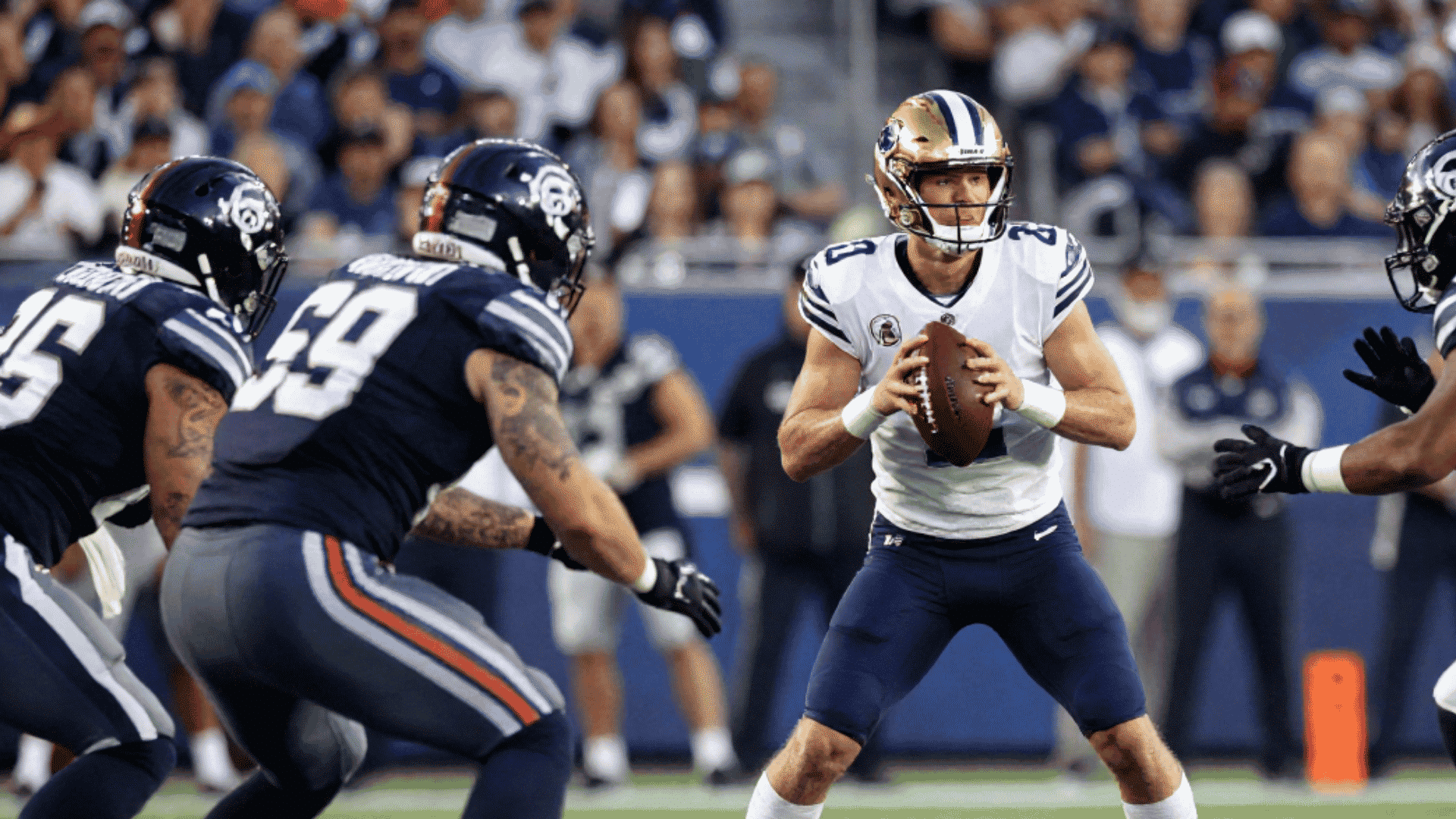 quarterback preparing to throw while defenders apply pressure during an nfl football game
