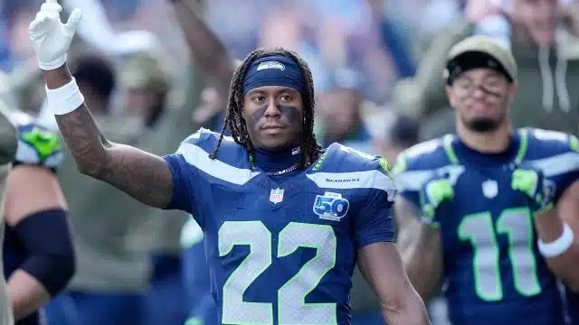 rashid shaheed raising his fist while wearing a seattle seahawks jersey on the field