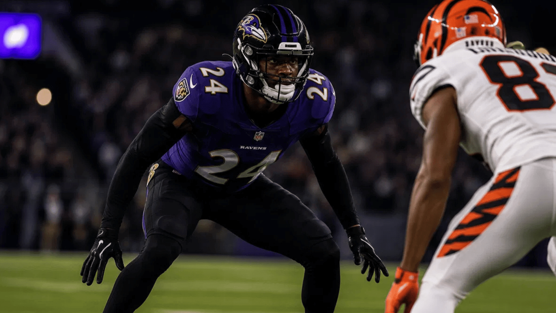 ravens cornerback number 24 in press coverage against bengals wide receiver number 83