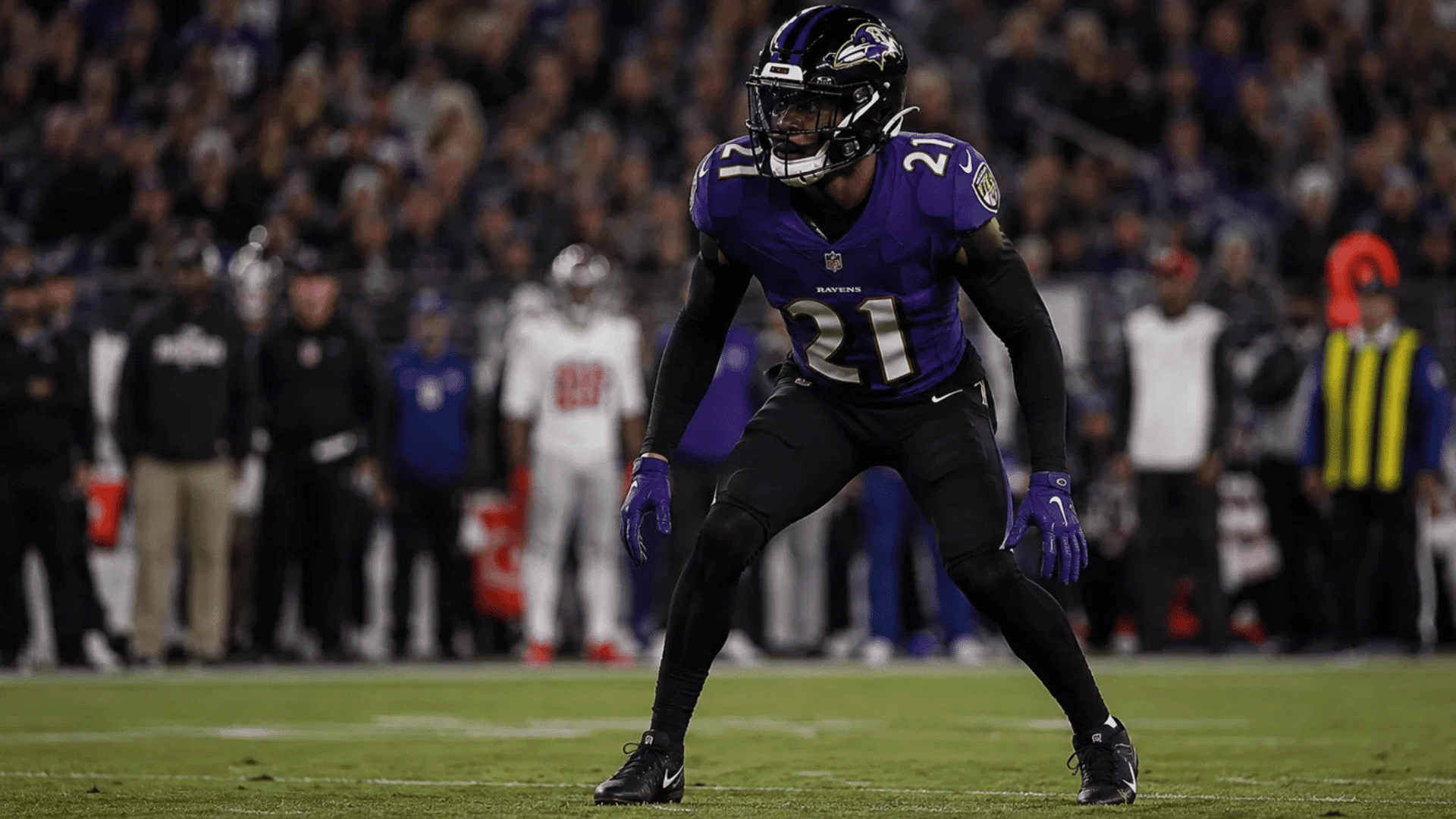 ravens nickelback number 21 in a lowered stance reading the offense during a night game