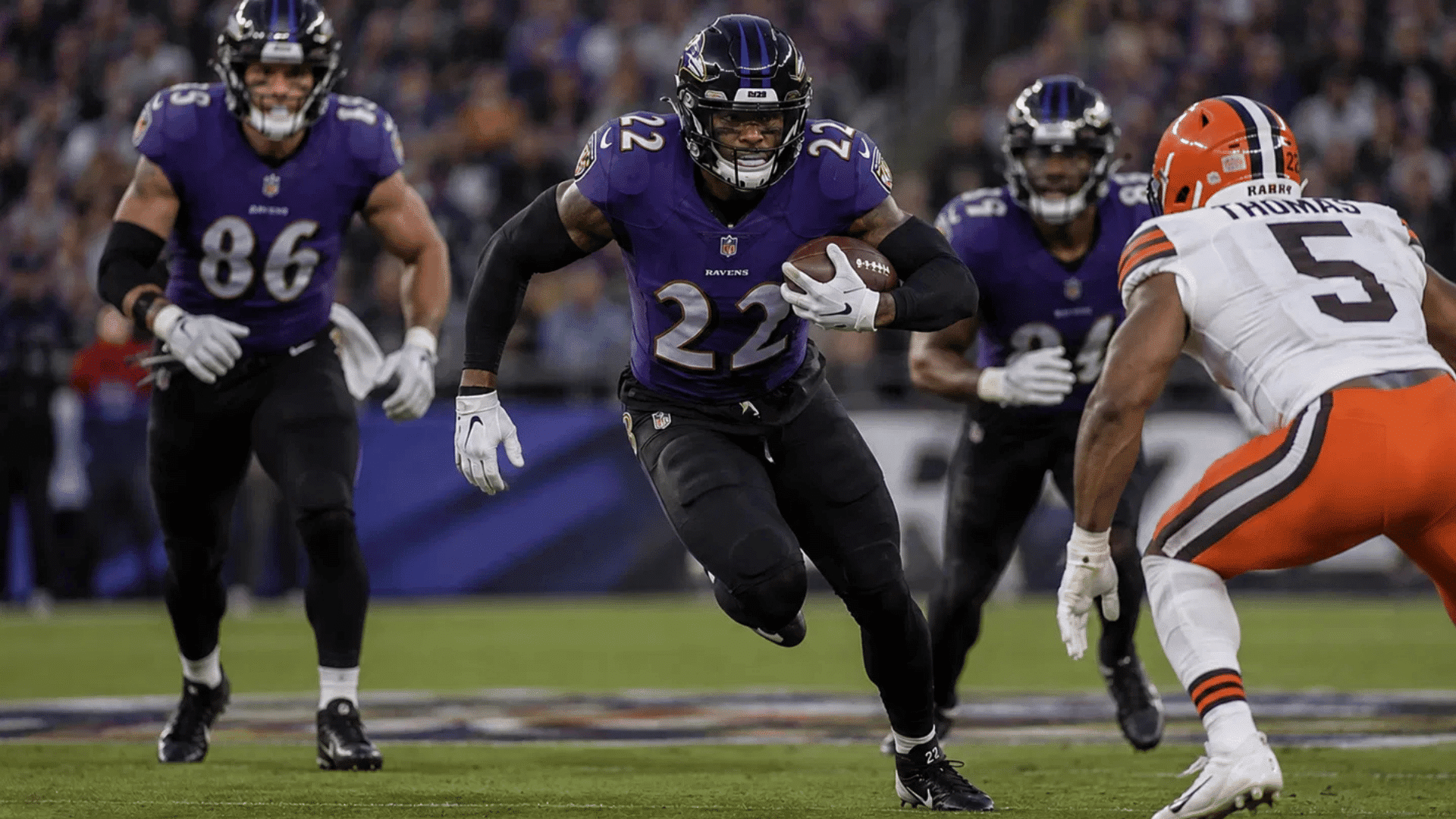 ravens number 22 carries the ball on a rushing play during an nfl game