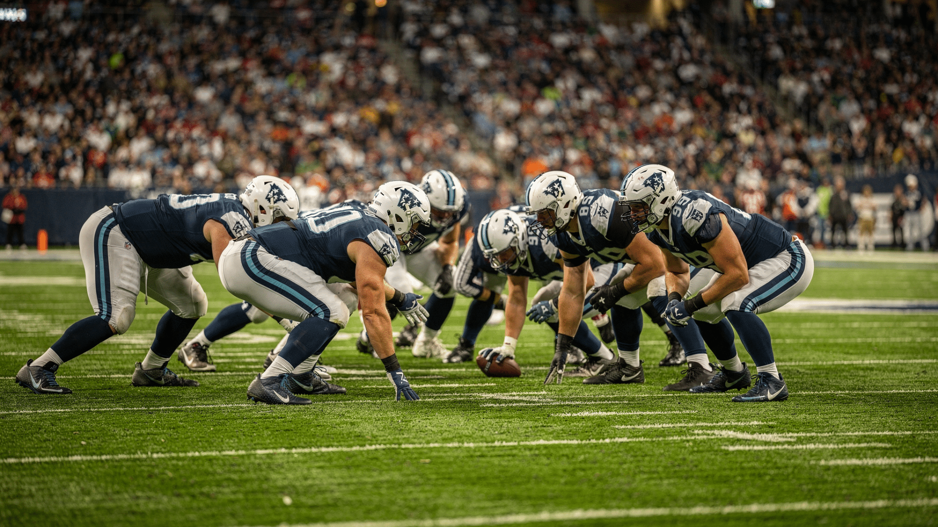 real american football game with two tight ends lined up on the offensive line under stadium lights on a green grass field