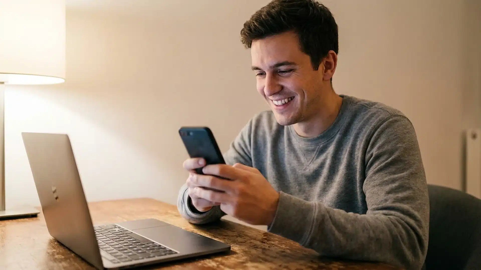 man holding a smartphone while typing a message to invite friends to a fantasy league