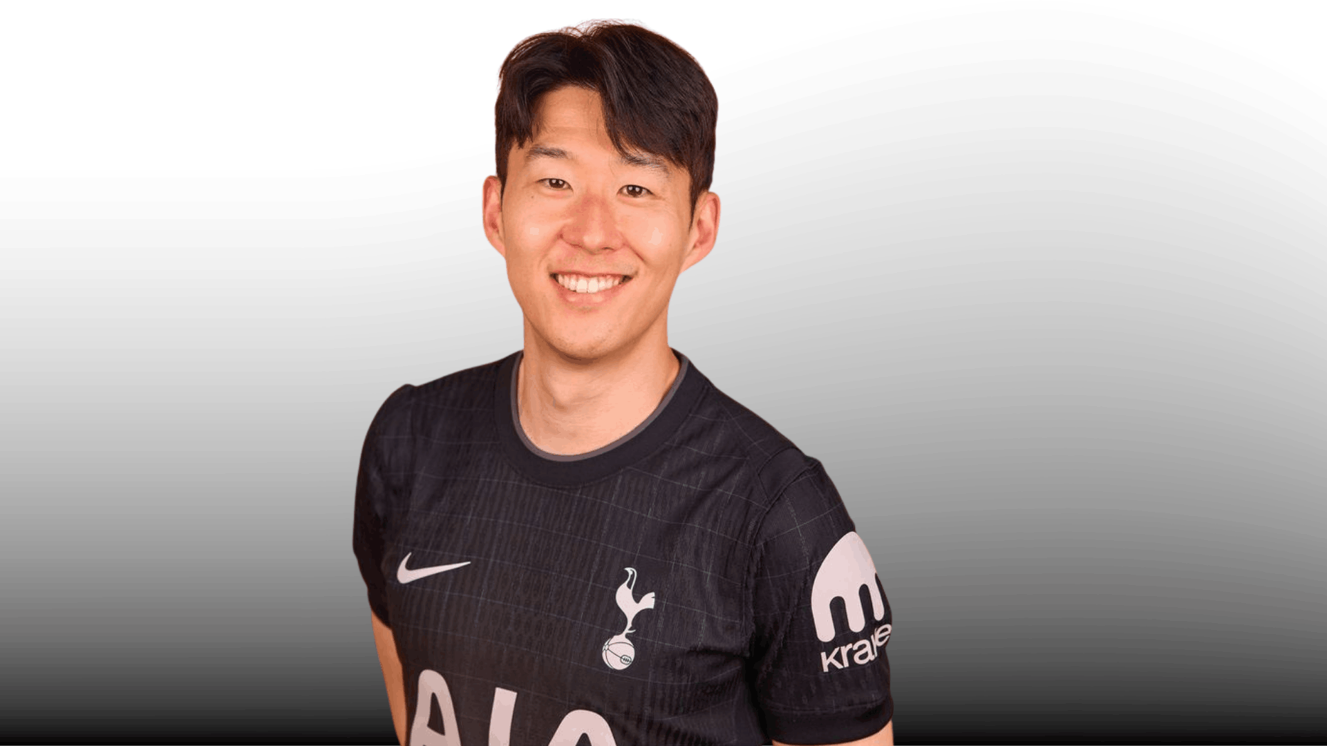 smiling soccer player with side swept short haircut wearing black jersey on gray gradient background