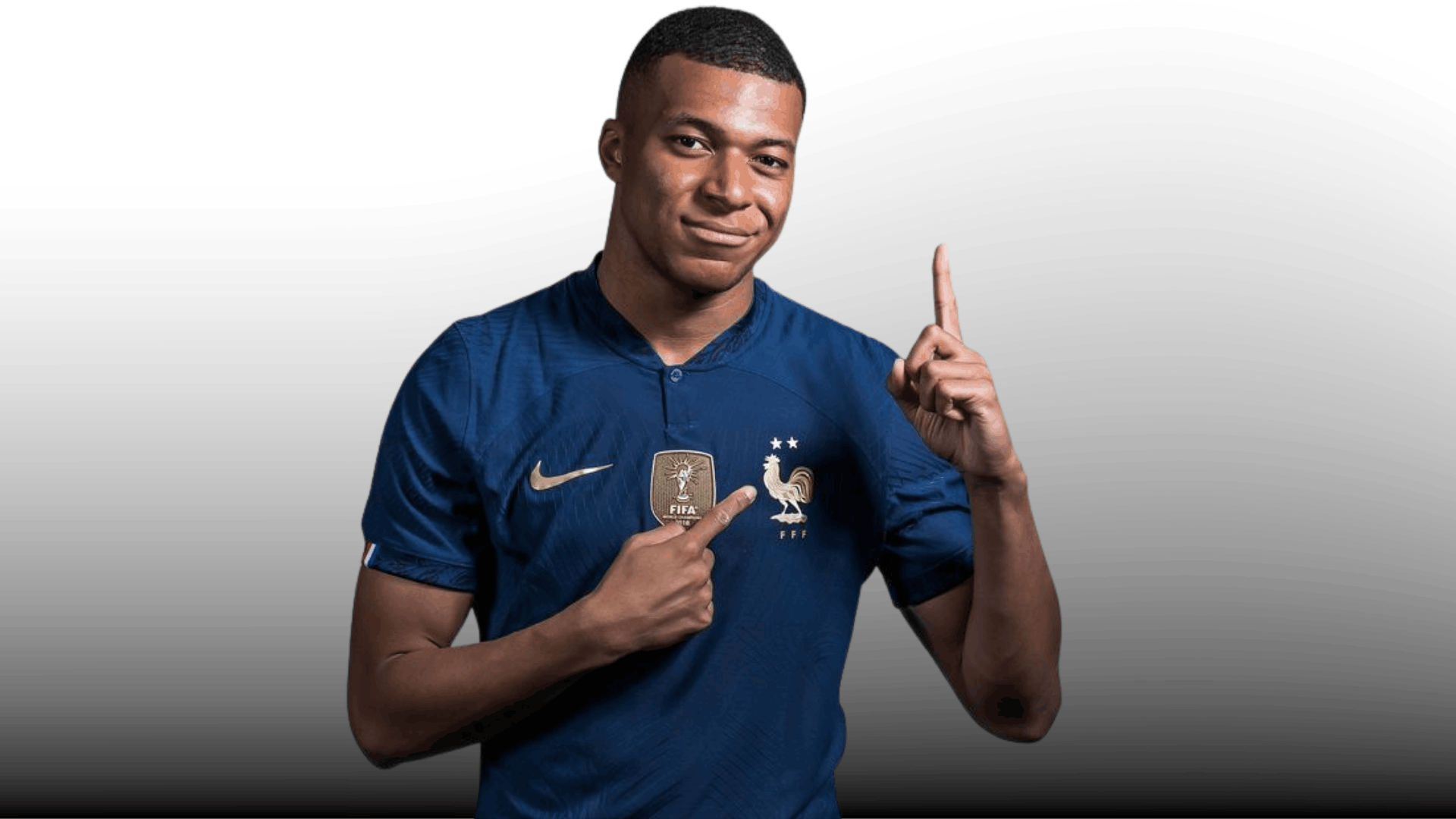 soccer player in blue jersey showing a short buzz cut fade while pointing upward on a plain background