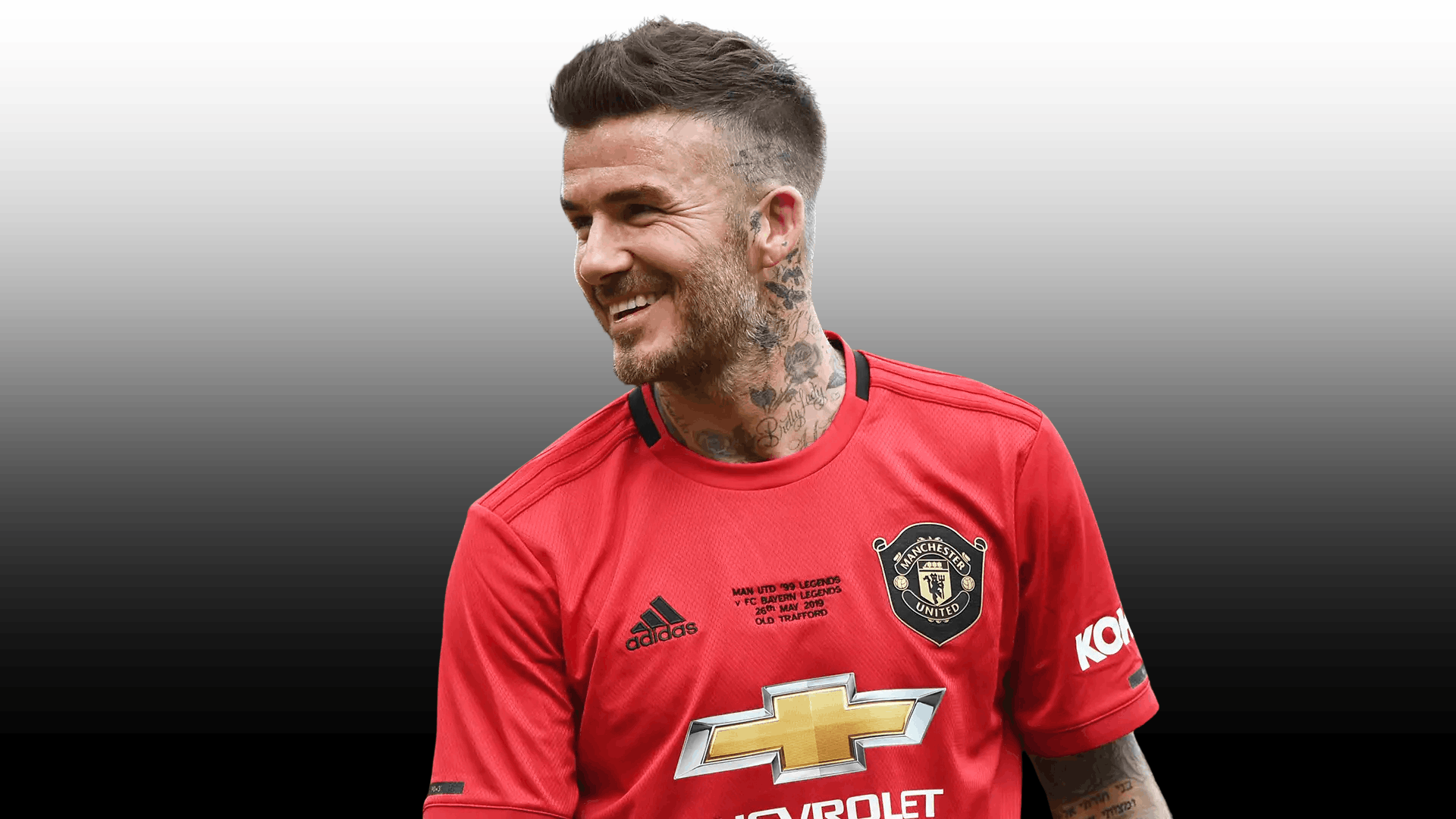 soccer player with textured quiff fade haircut red jersey neck tattoos and smiling expression