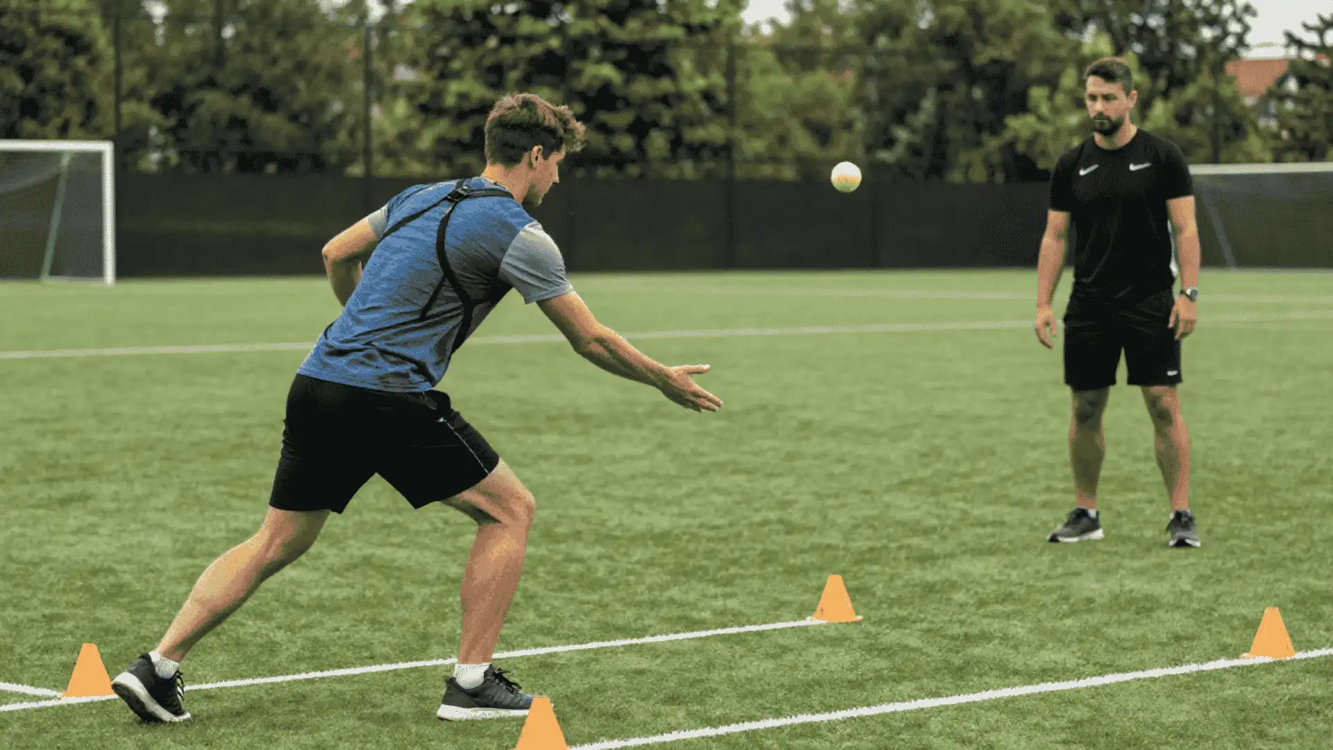 football player reaching for a tennis ball during a cone drill for reaction speed and body control