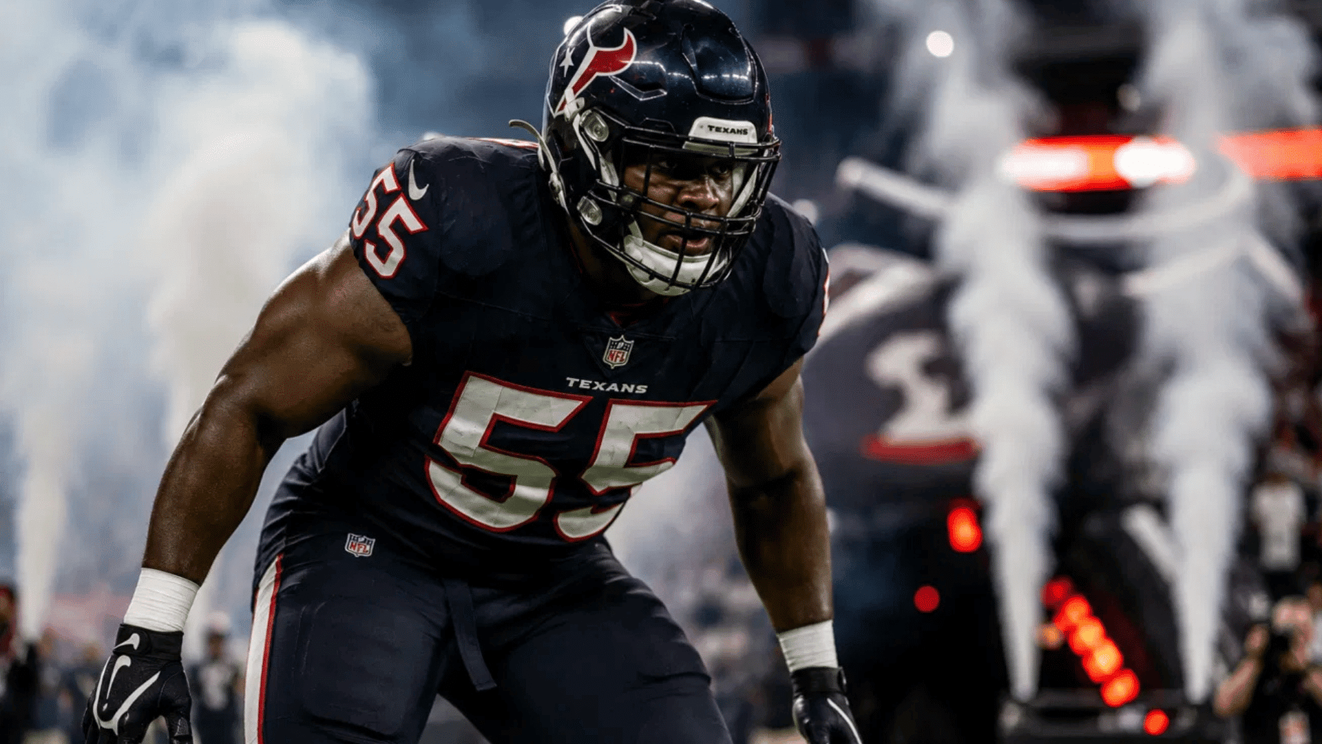 texans defensive end number 55 charging onto the field through smoke and pyrotechnics