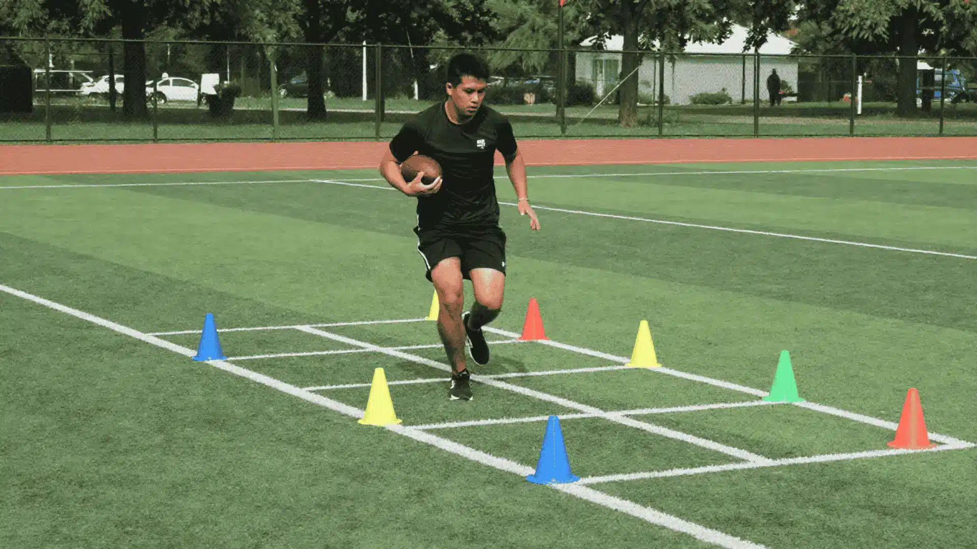 football player running through a cone grid drill on turf to improve footwork balance and agility