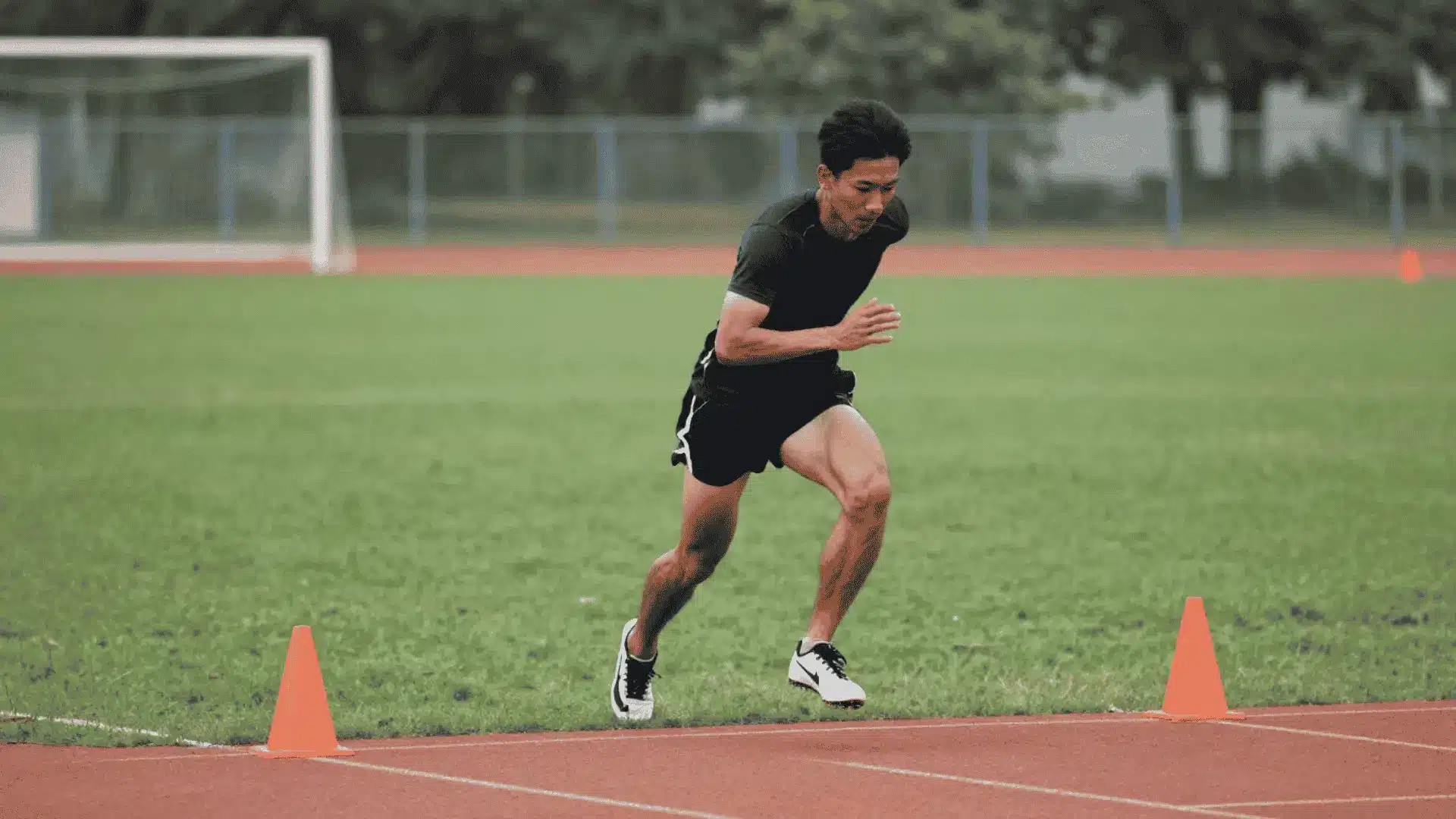 athlete cutting between orange cones on a track during a forty five degree speed drill