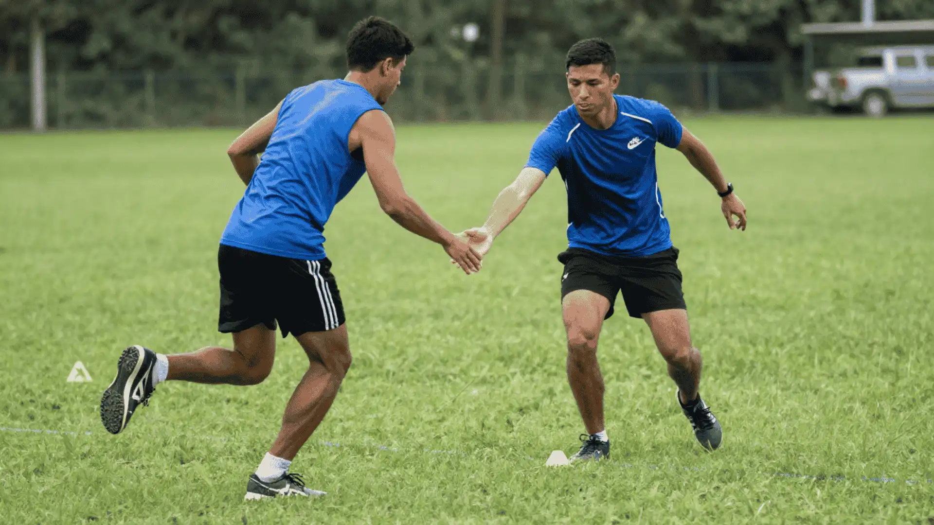 football players practicing quick handoff and reaction movement during a gap simulation drill on grass