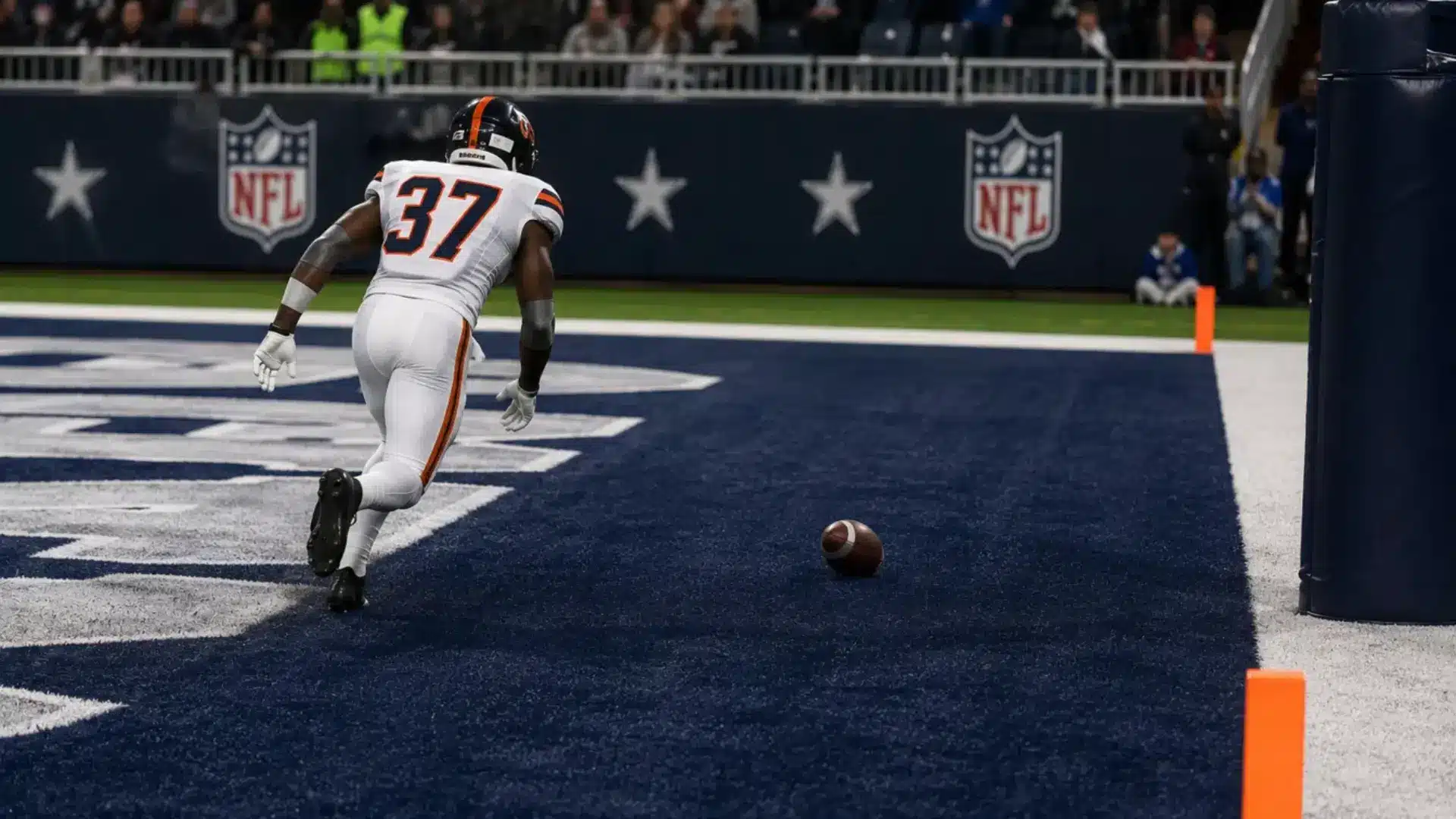 football player fumbling into the end zone with officials signaling a touchback during a game