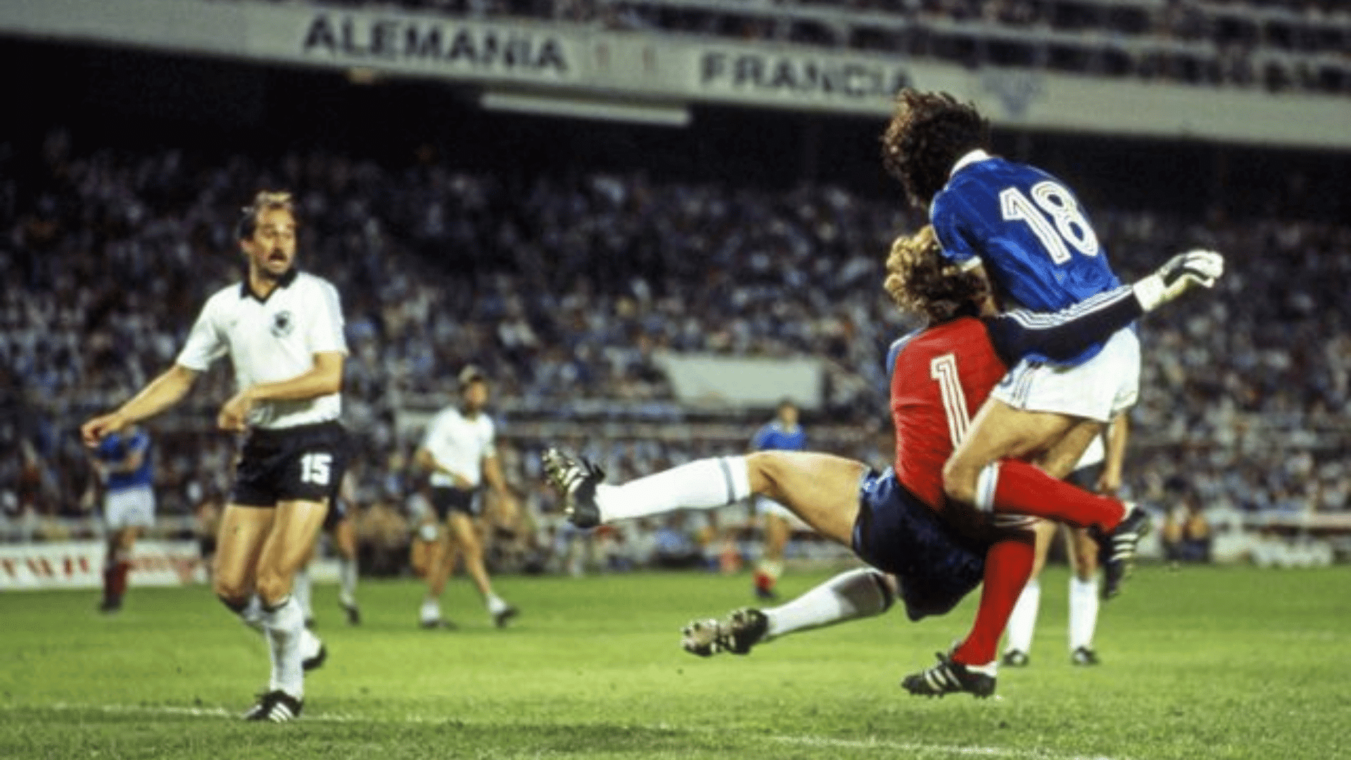two soccer players collide midair during a match as another player watches from the field in a crowded stadium