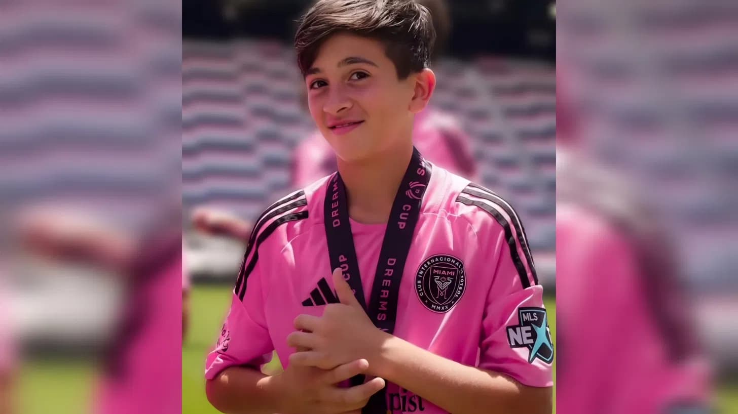 wearing his inter miami jersey and dreams cup medal as he plays youth soccer
