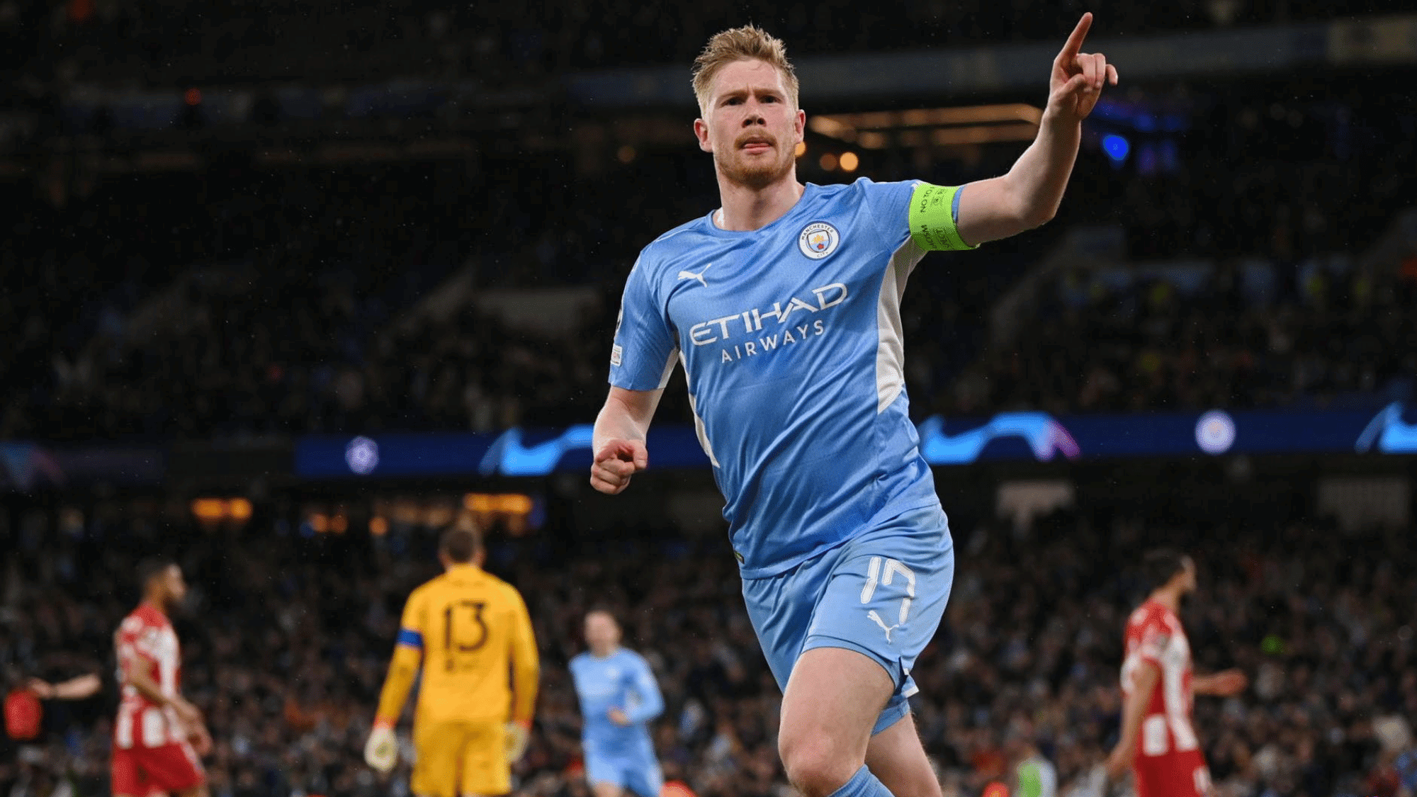 wide angle focus shot on kevin de bruyne celebrating his goal in his manchester city jersey pointing towards the audience
