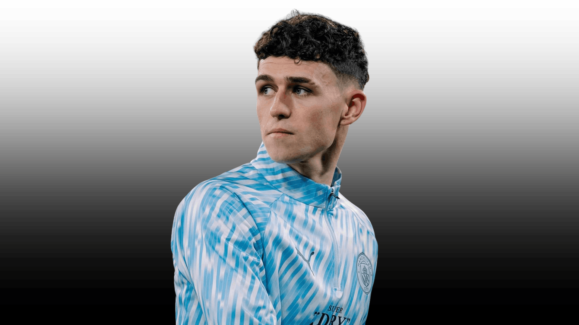 young soccer player with curly crop fade haircut wearing blue patterned training top on dark background