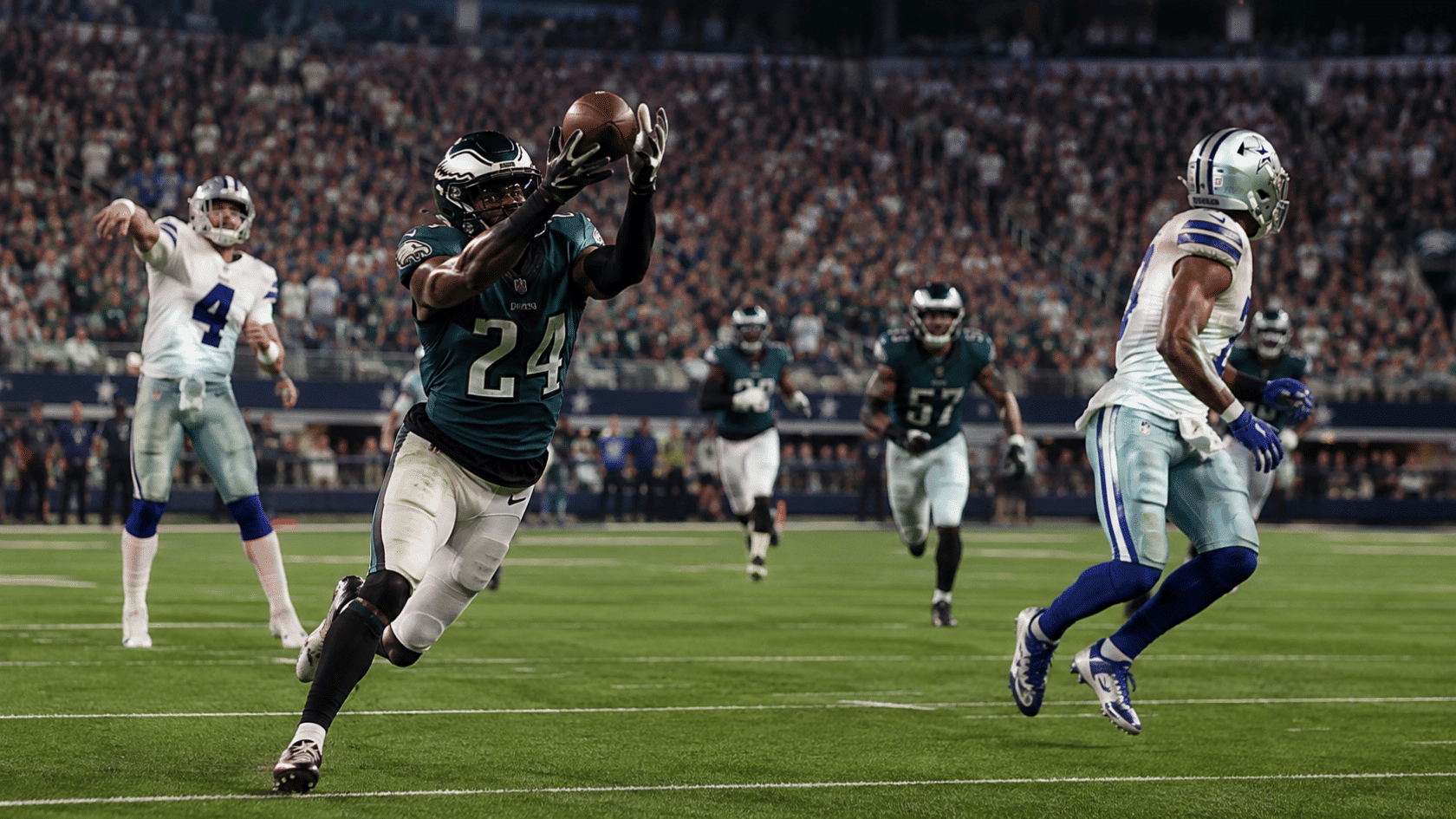 football player in a teal jersey catches a pass in midair during a night game under stadium lights