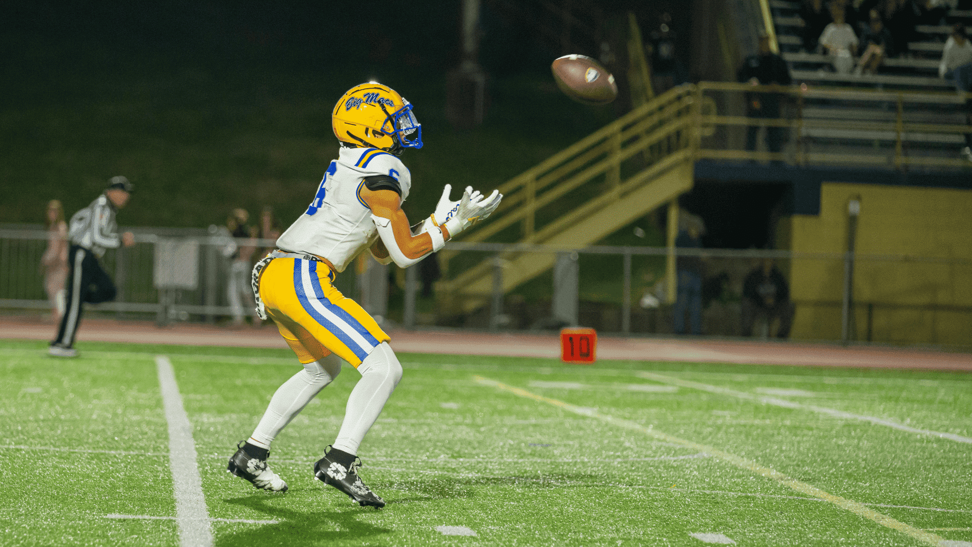 football player preparing to catch a pass with both hands during receiver practice on the field