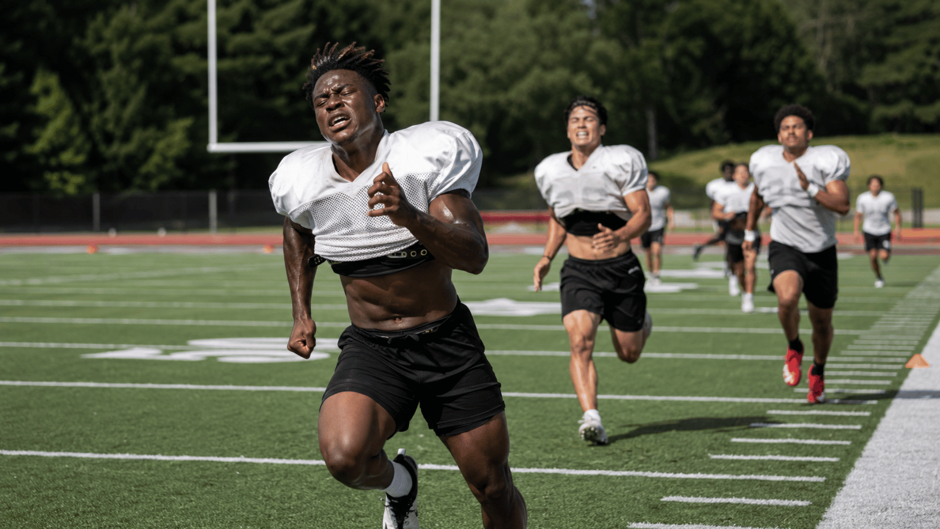 football players pushing through the final yards of a full gasser sprint rep at practice