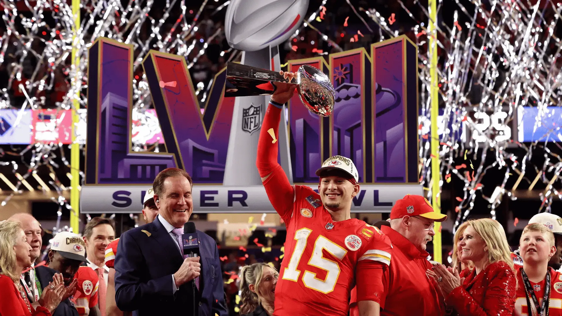 football quarterback holding championship trophy during confetti filled postgame celebration