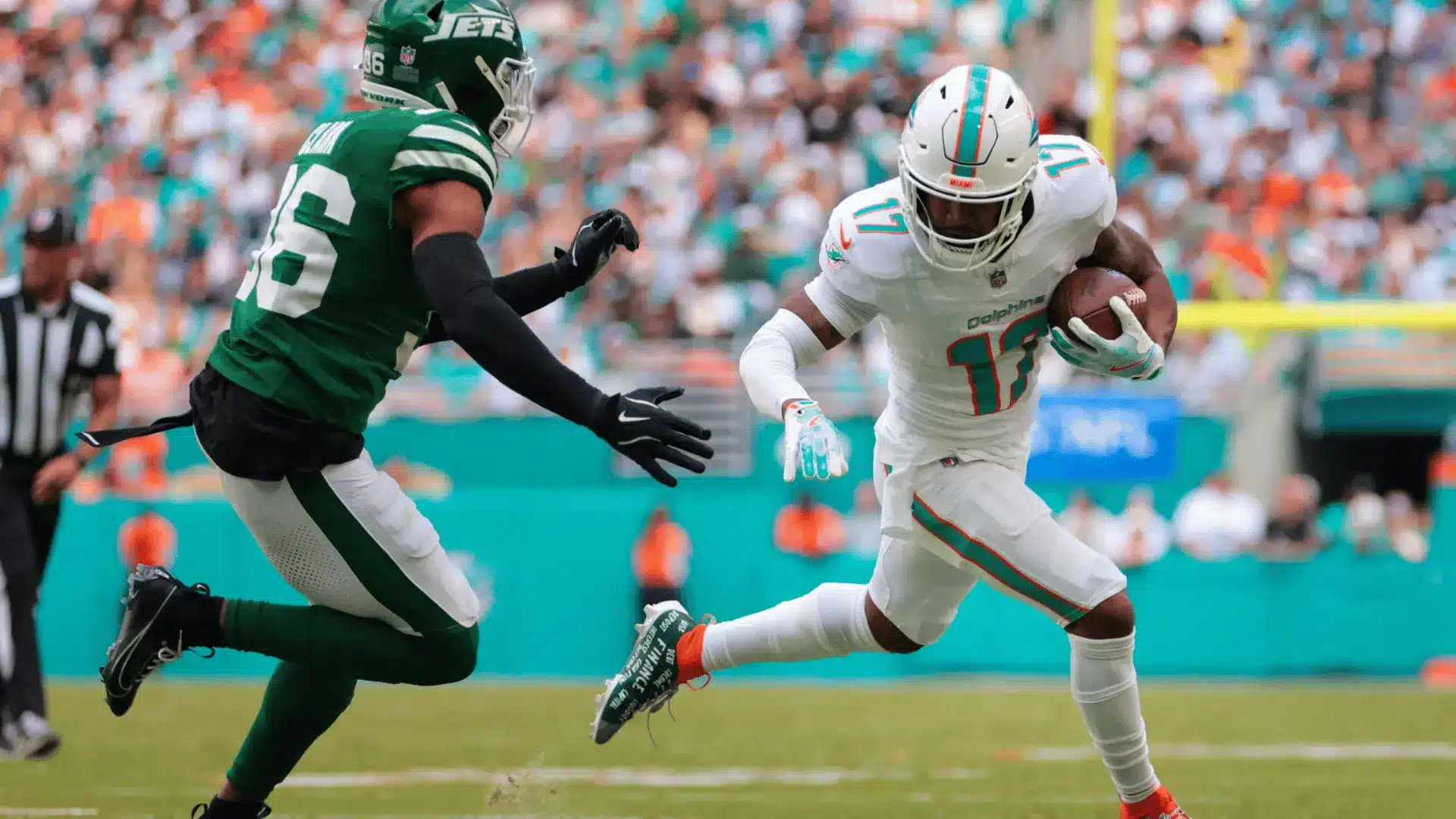football wide receiver running with the ball while defender closes in during live game action
