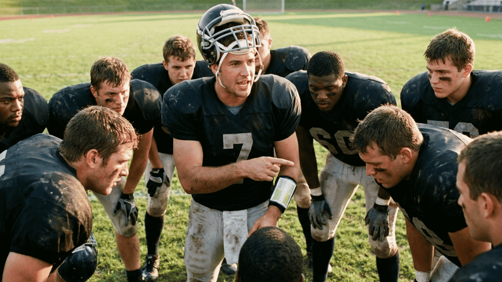 quarterback leading teammates in an offensive huddle while explaining the play before the snap