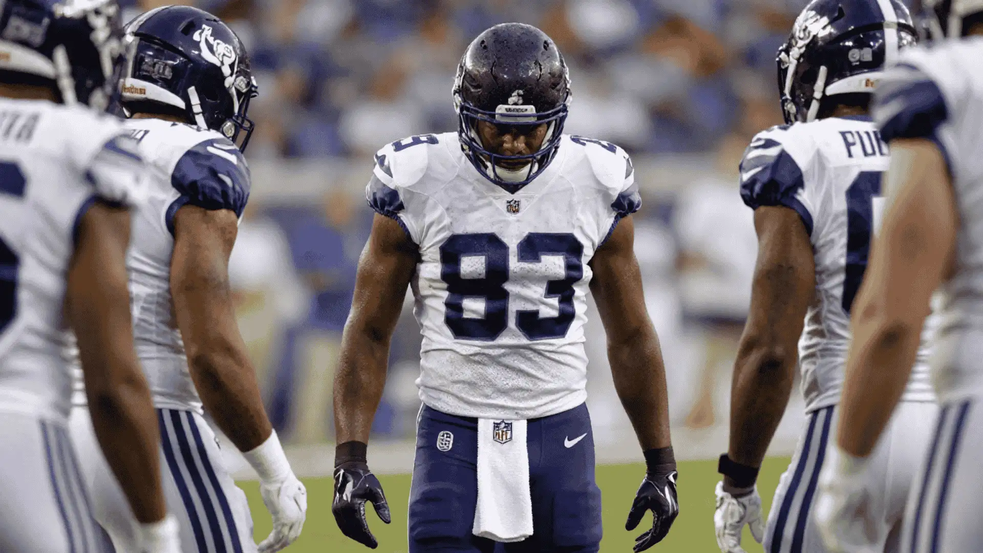 running back stands between teammates before the next play during a crowded football game