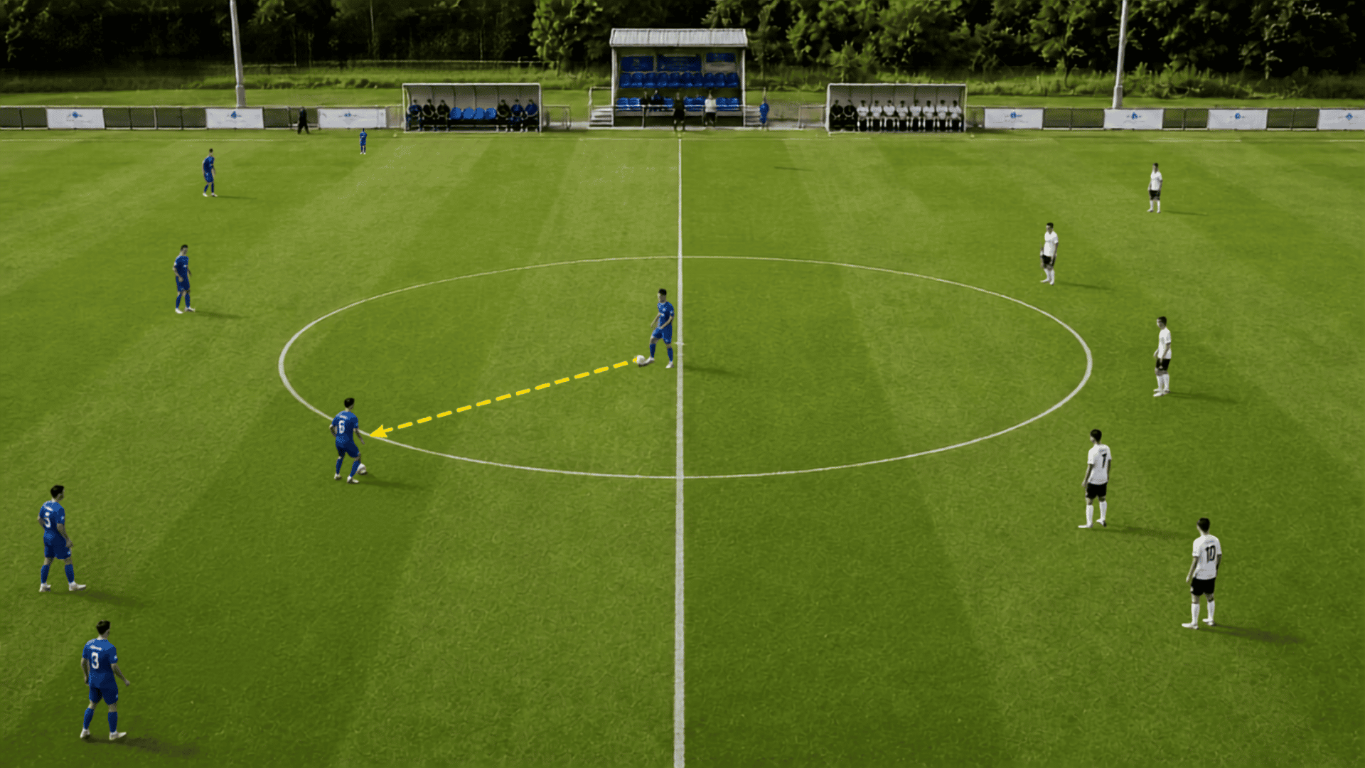 soccer kickoff at the center mark showing players spreading out as the first pass begins play