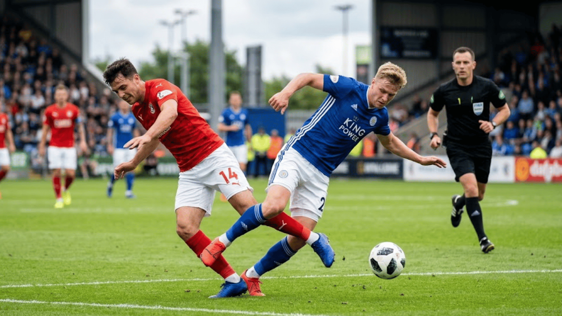 soccer players make accidental leg contact while chasing a loose ball as a referee watches the play nearby