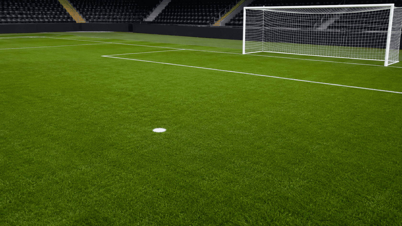 the penalty spot is clearly visible on the green soccer field positioned directly in front of the goal
