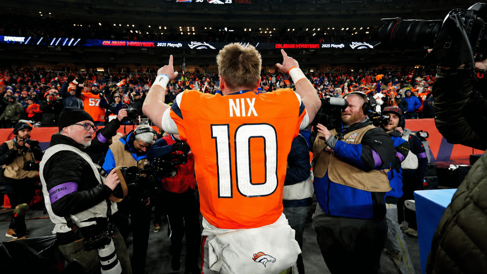 broncos quarterback Bo Nix celebrates with raised hands as photographers gather around him