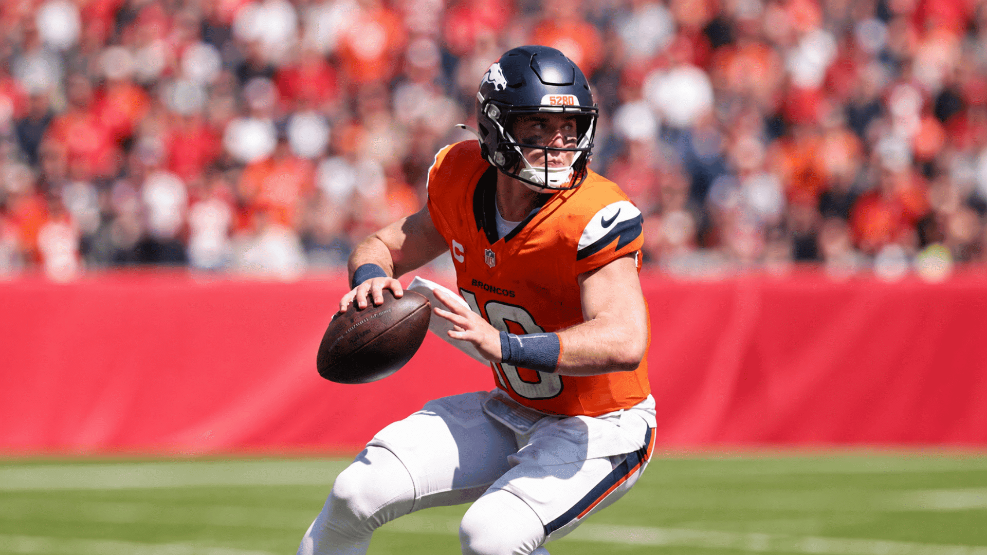denver broncos quarterback holds football and looks downfield during an nfl game