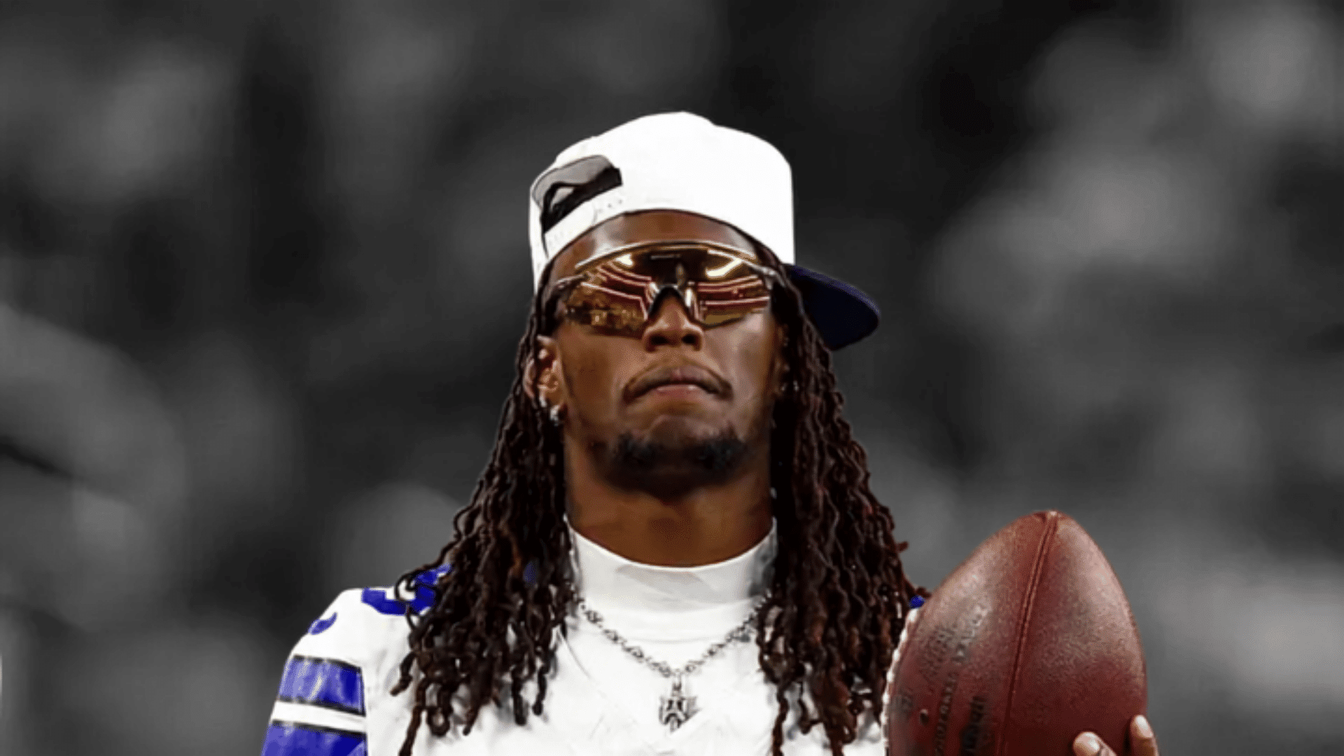 cowboys receiver wearing sunglasses and holding a football before a game
